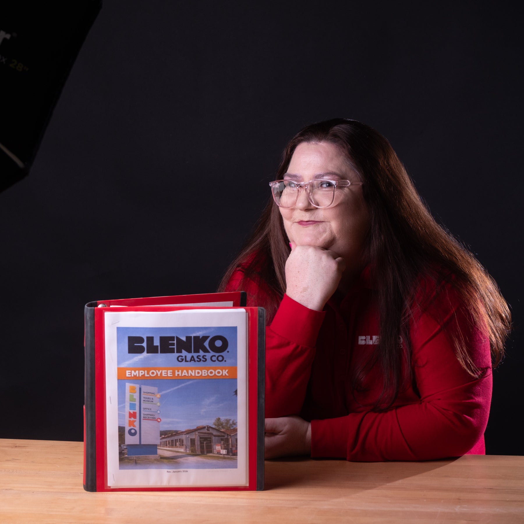 Woman with handbook standing against a black background