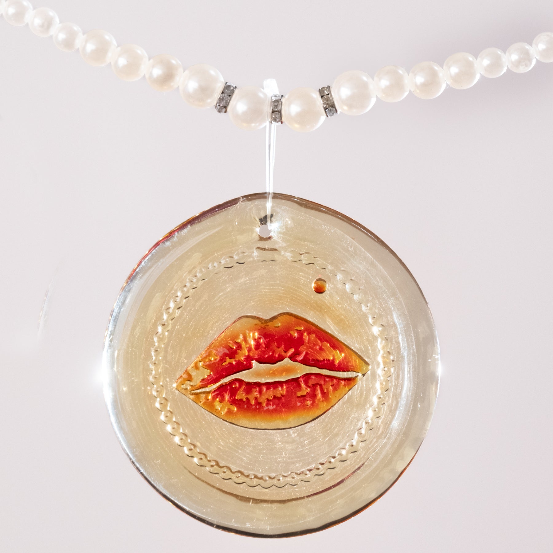Tangerine Suncatcher on a pearl necklace with white background