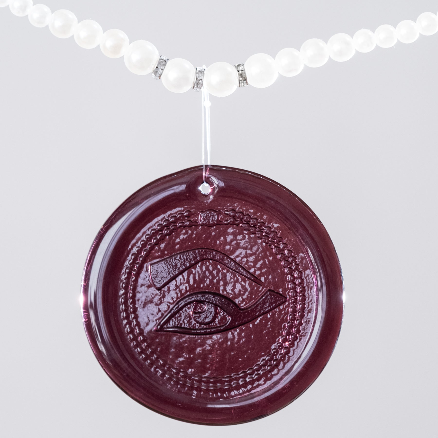 Purple Suncatcher on a pearl necklace with white background