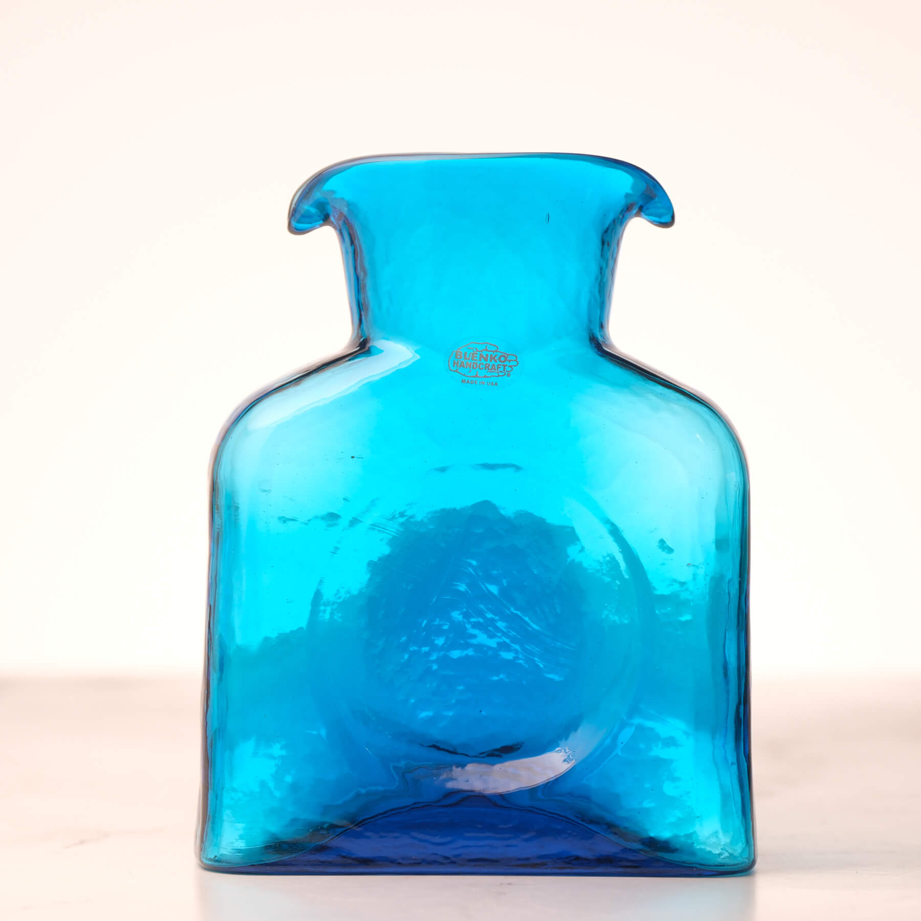 Blue glass vase on a light beige background