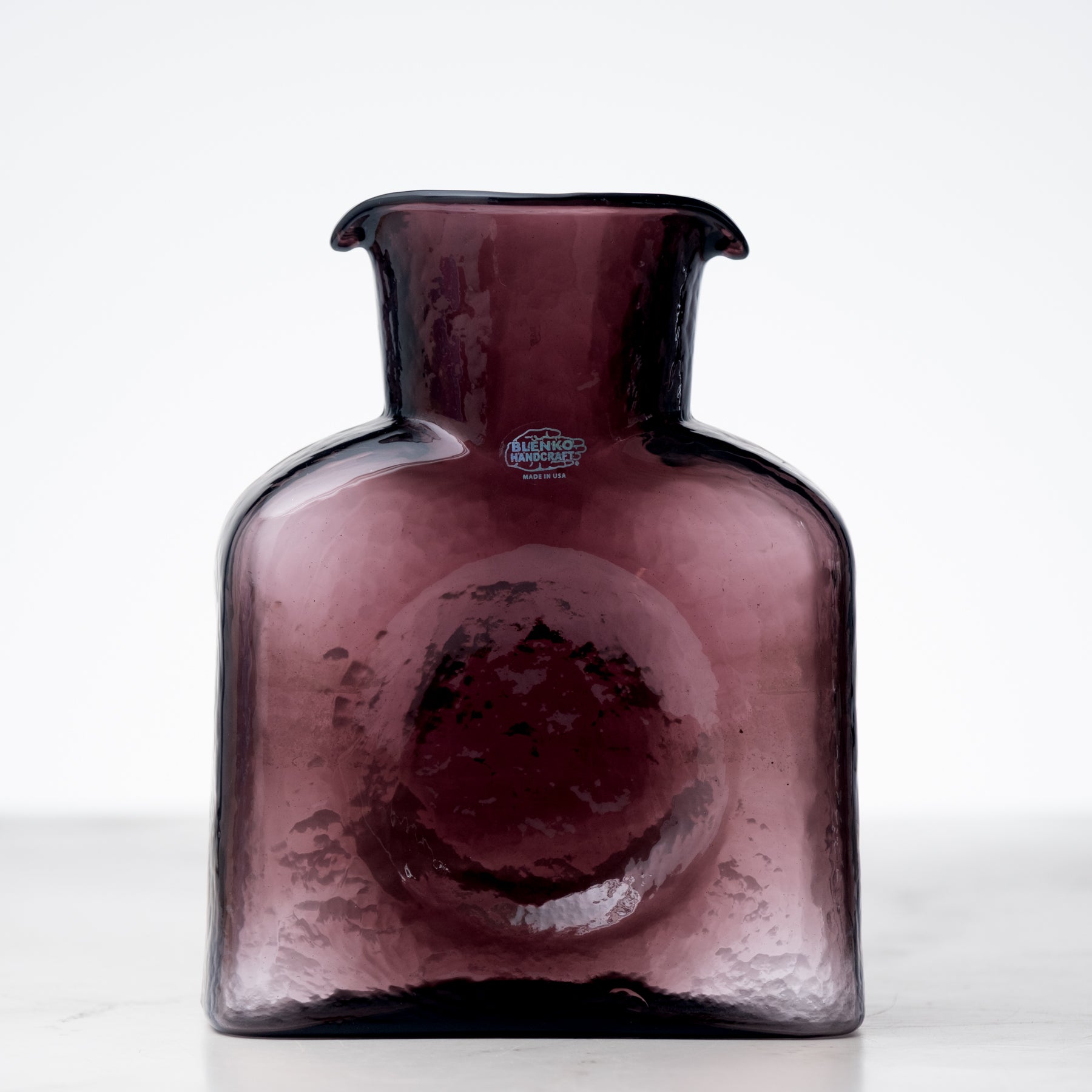 Amethyst-colored glass vase with a logo on a white background