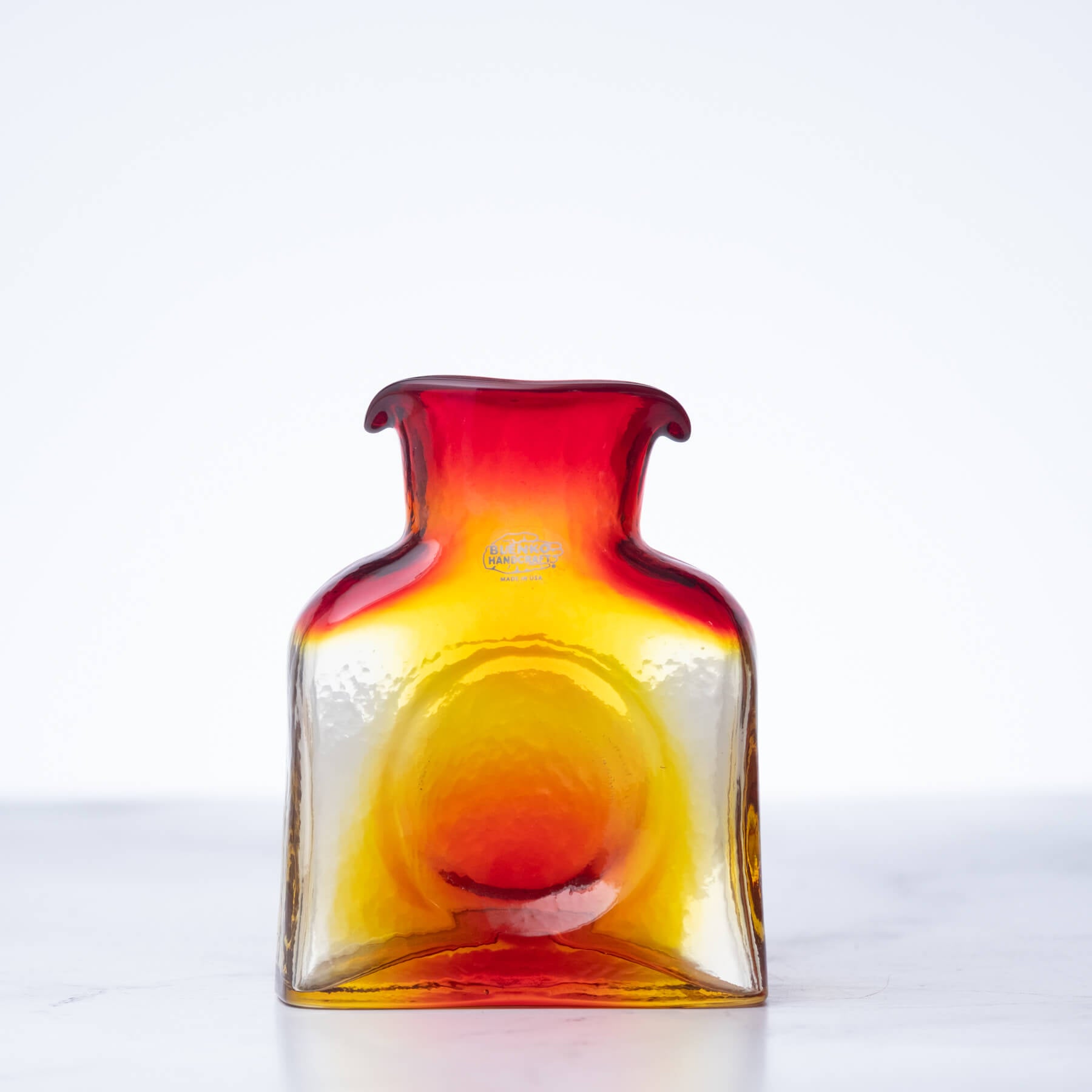 Colorful glass bottle with a gradient from red to yellow on a white background
