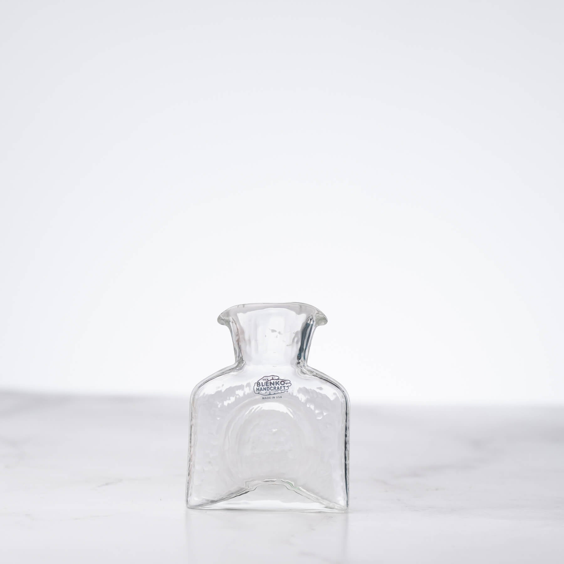 Clear glass carafe on a white background