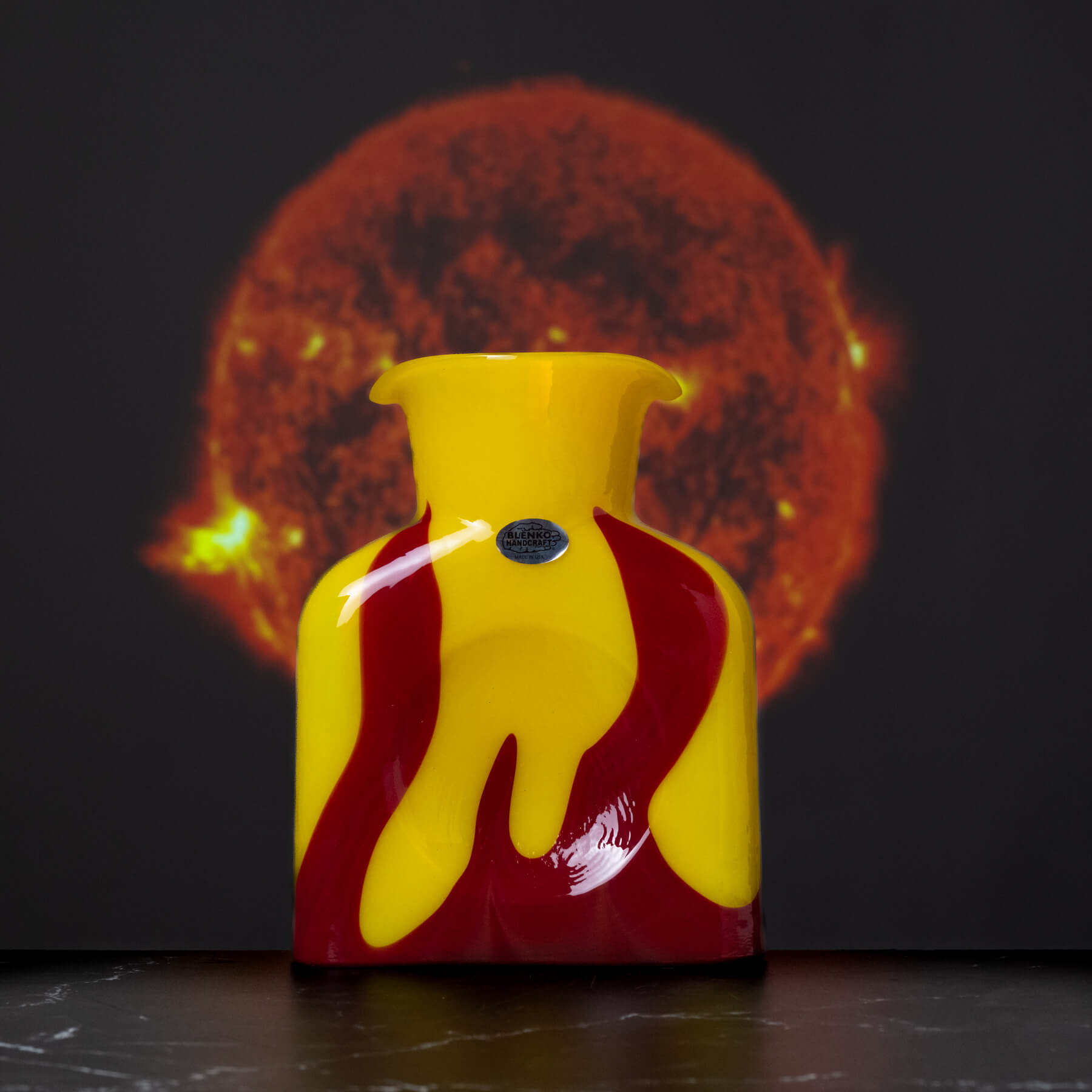 Yellow and red vase with a sun-like background