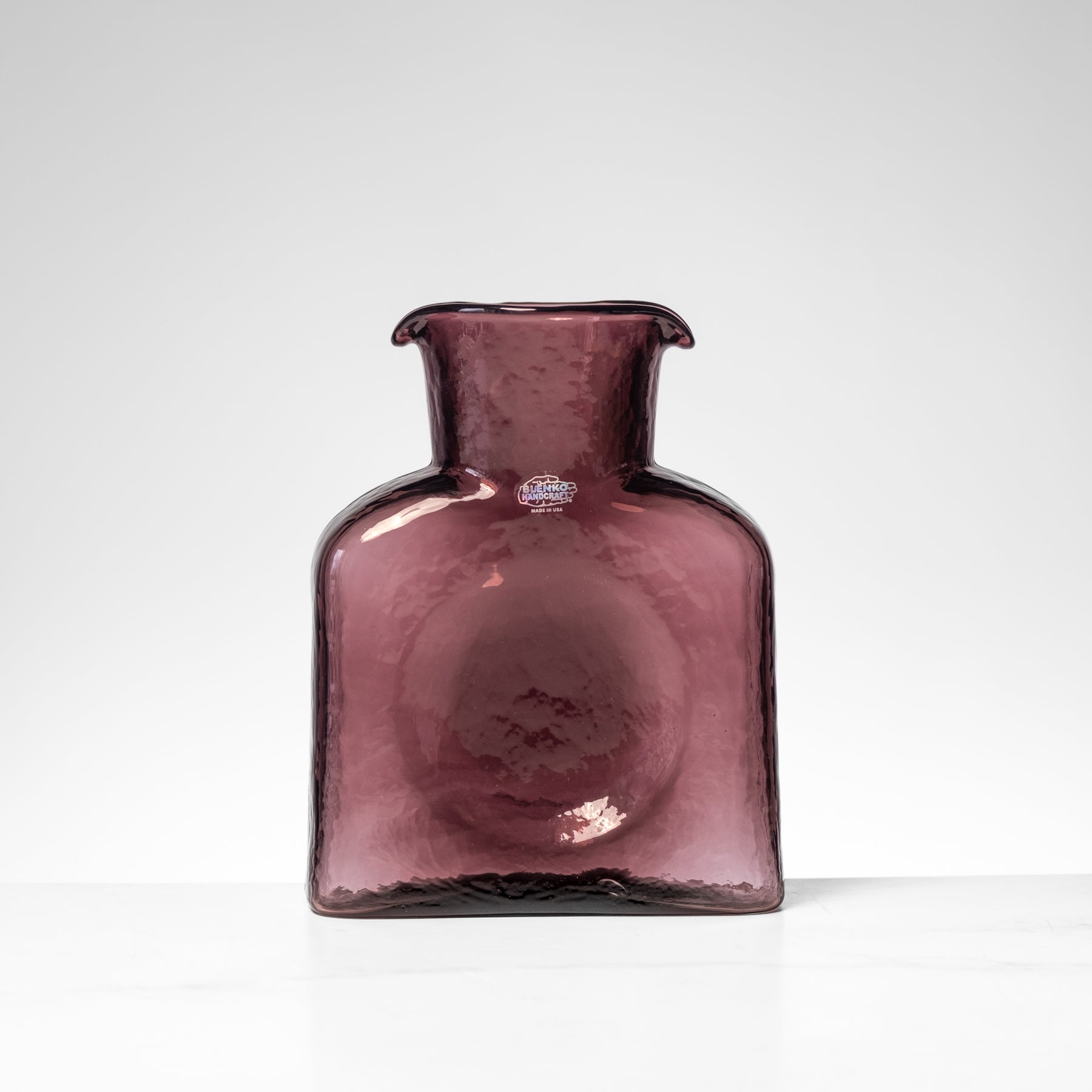 Purple glass vase on a white background