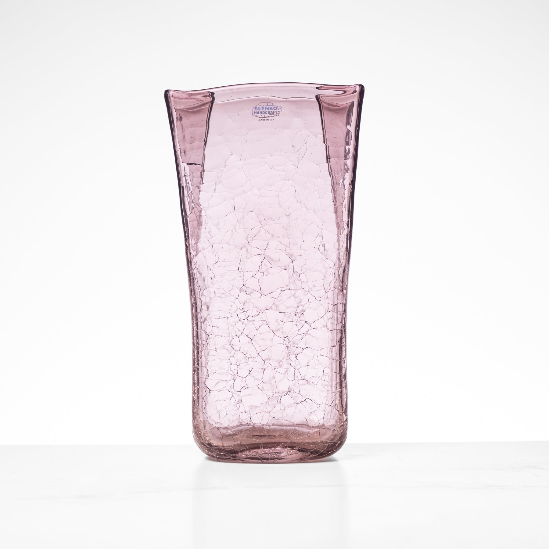 Pink glass vase with a cracked texture on a white background