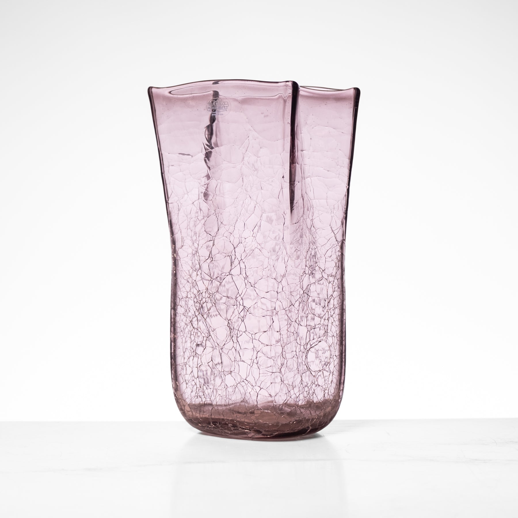 Pink glass vase with a crinkled texture on a white background