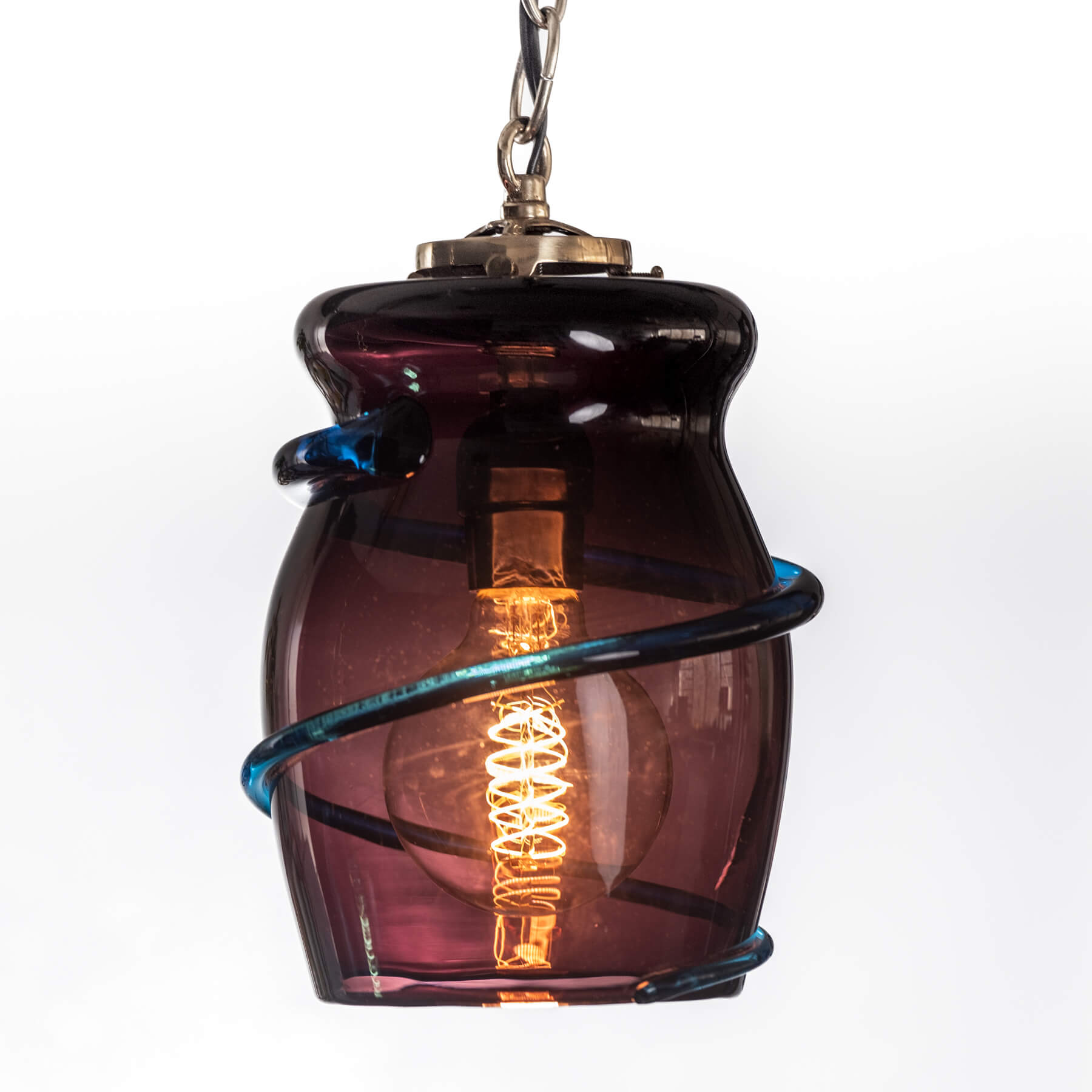 Amber glass pendant light with visible bulb on a white background
