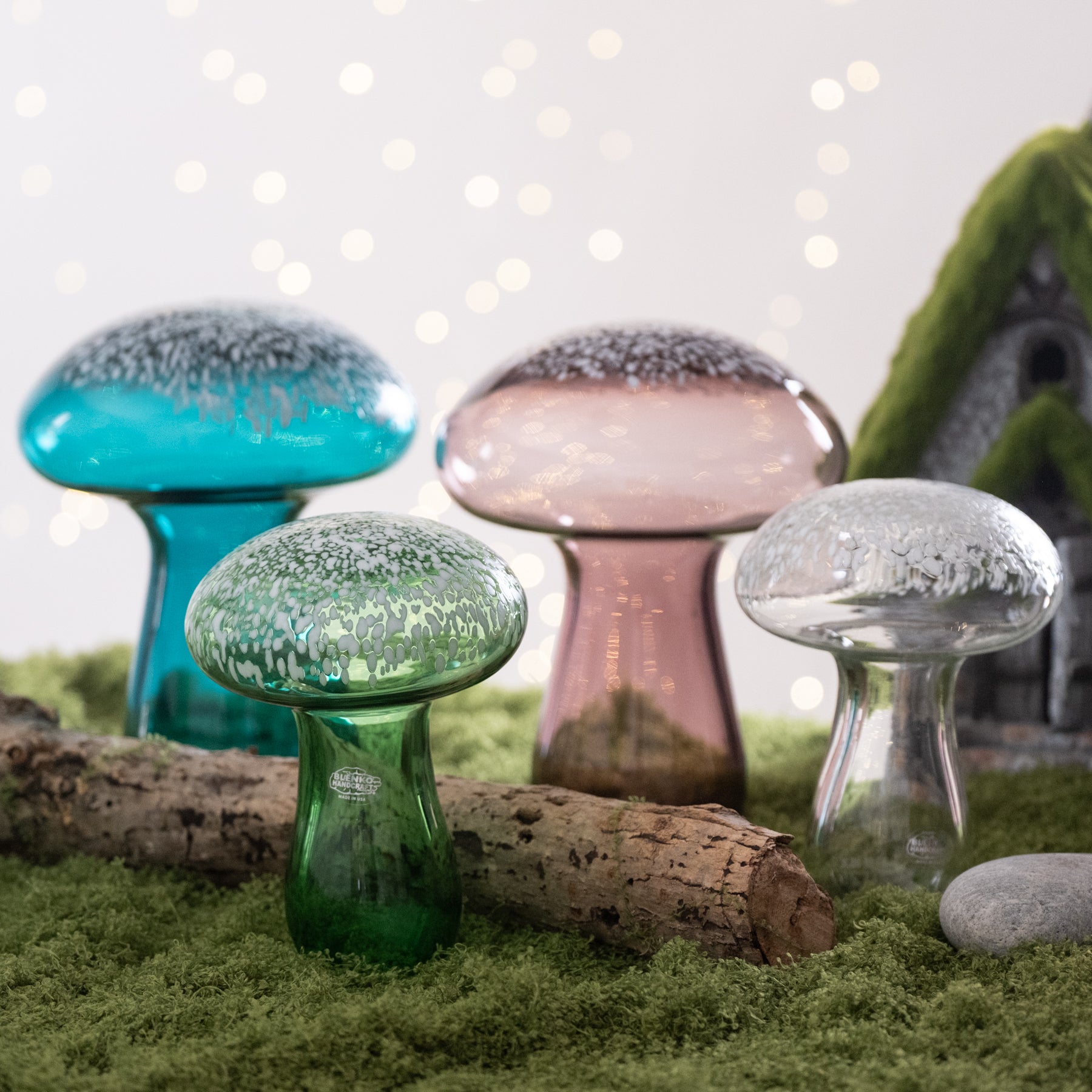 Colorful glass mushrooms on a grassy surface with a blurred background