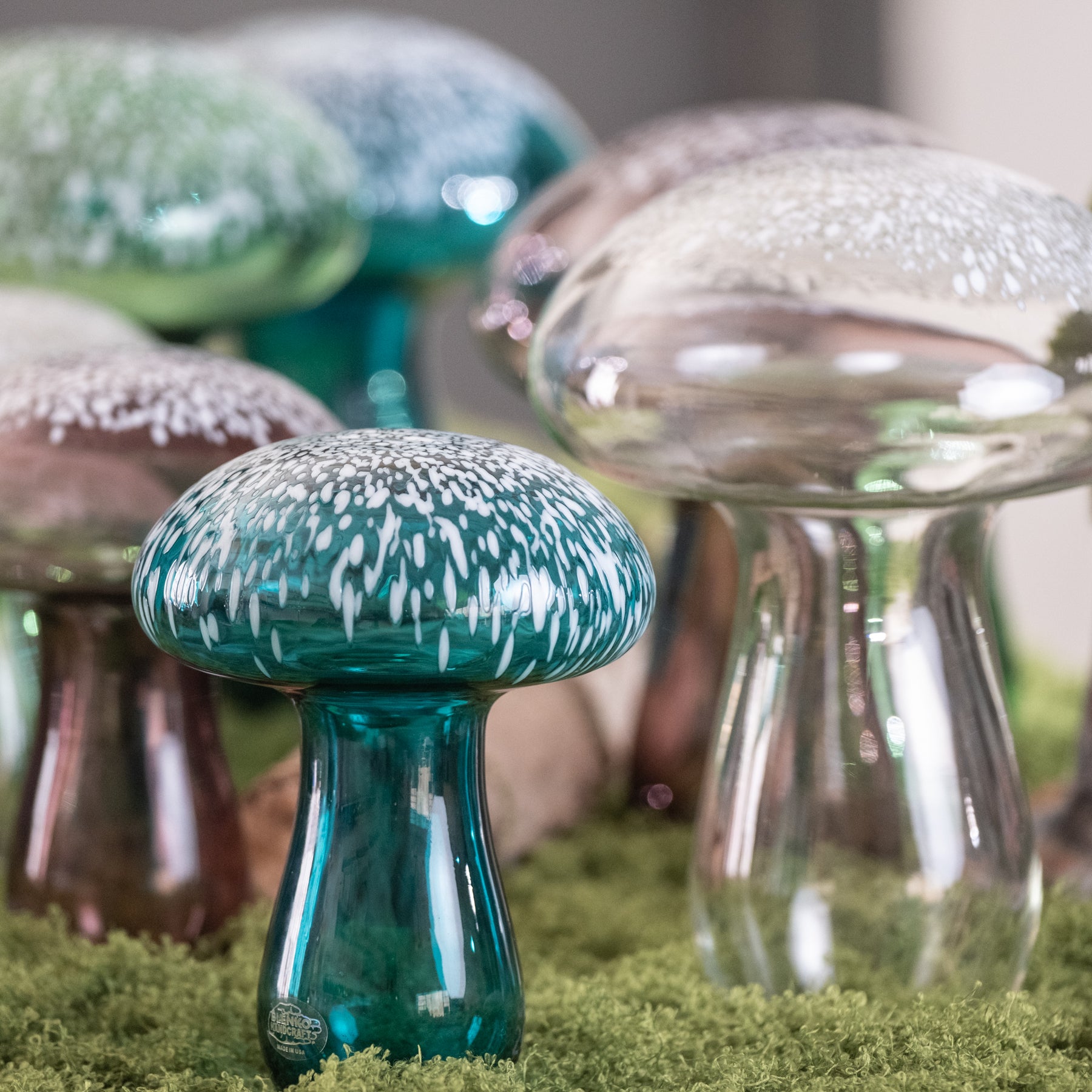 Glass mushroom decorations on a grassy surface