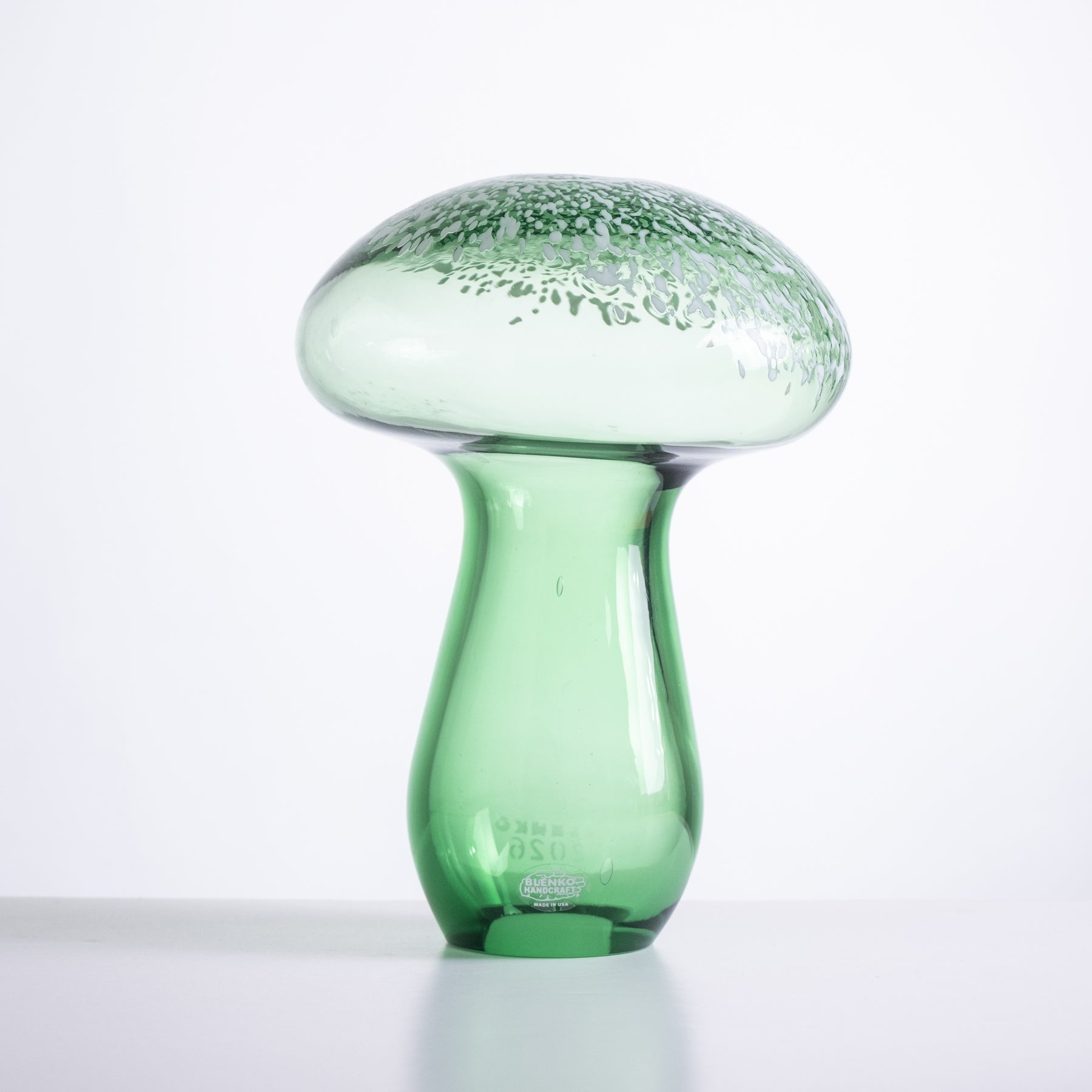 Green glass mushroom-shaped vase on a white background