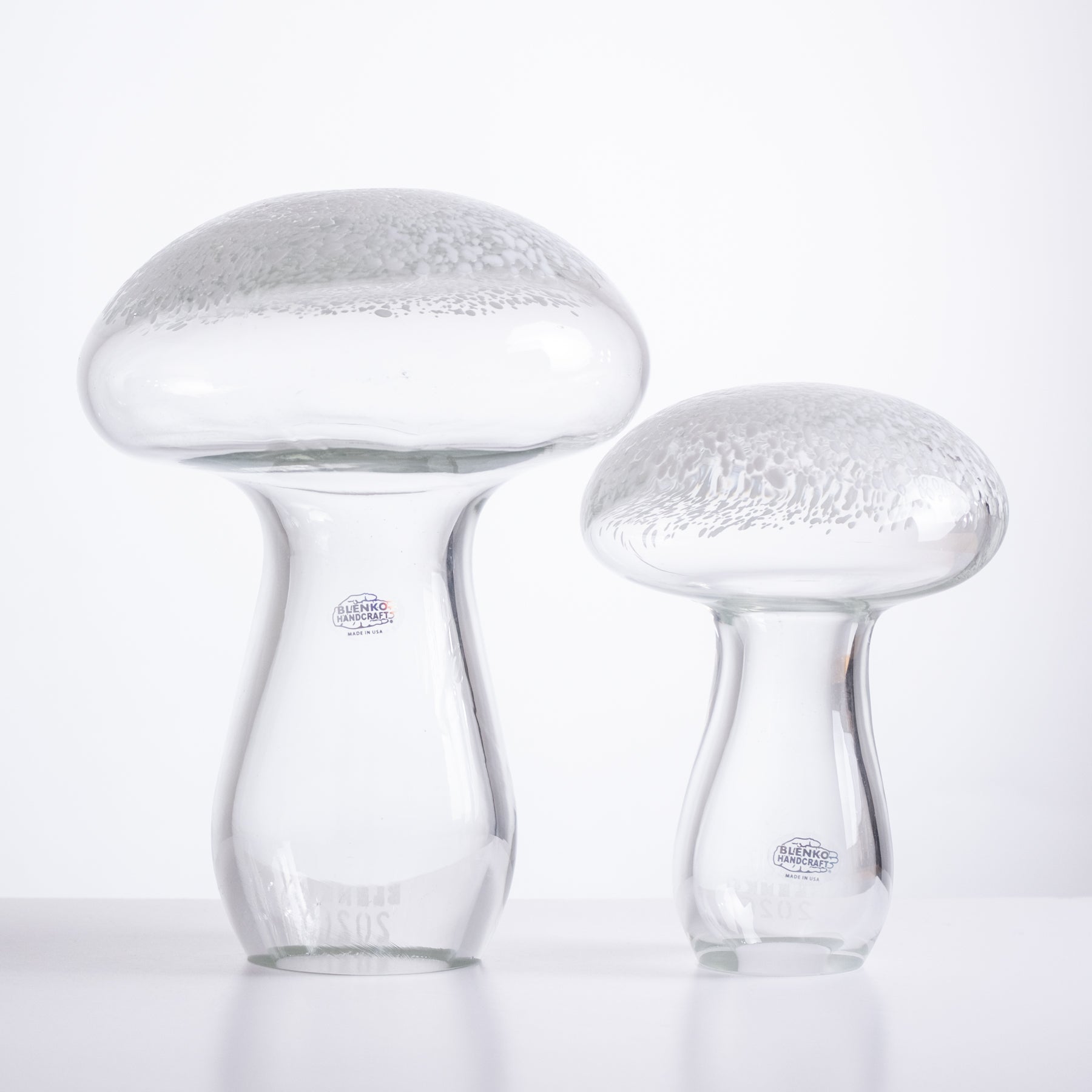 Two glass mushroom-shaped vases on a white background