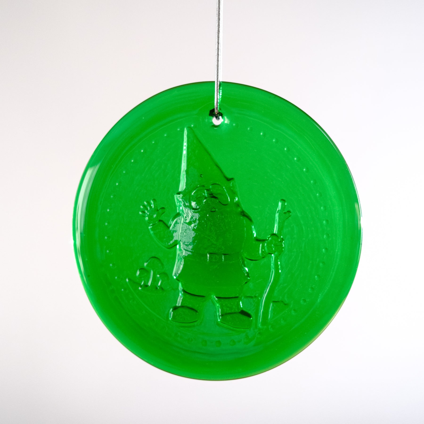 Green circular ornament with a Santa Claus design on a white background