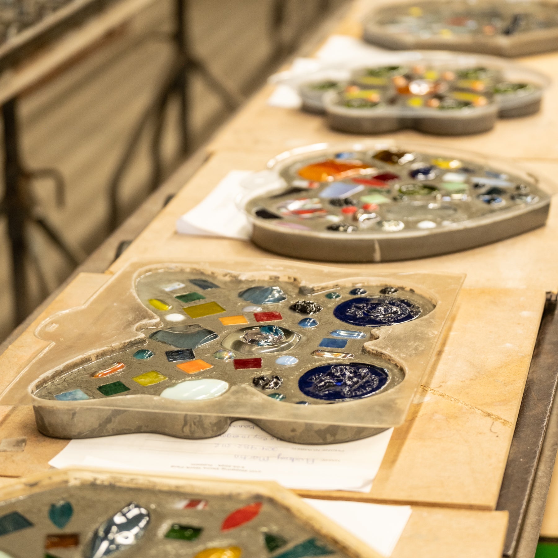 Artistic paint palettes with colorful pigments on a wooden table