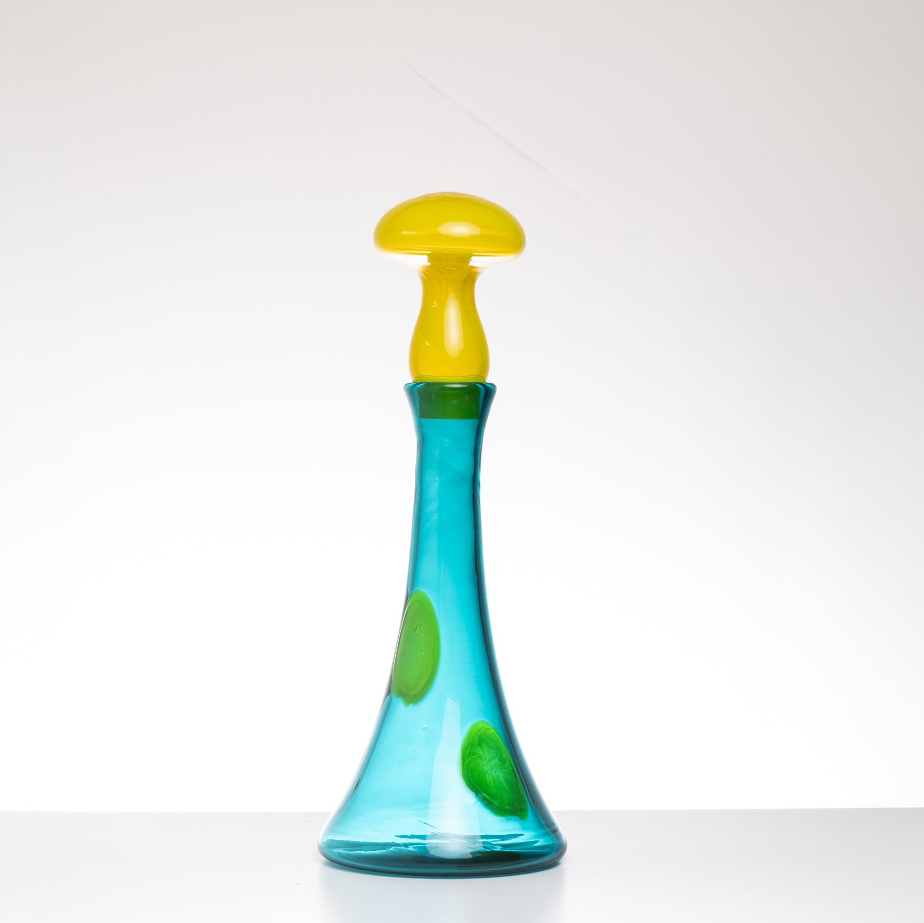 Colorful glass bottle with a yellow cap on a white background