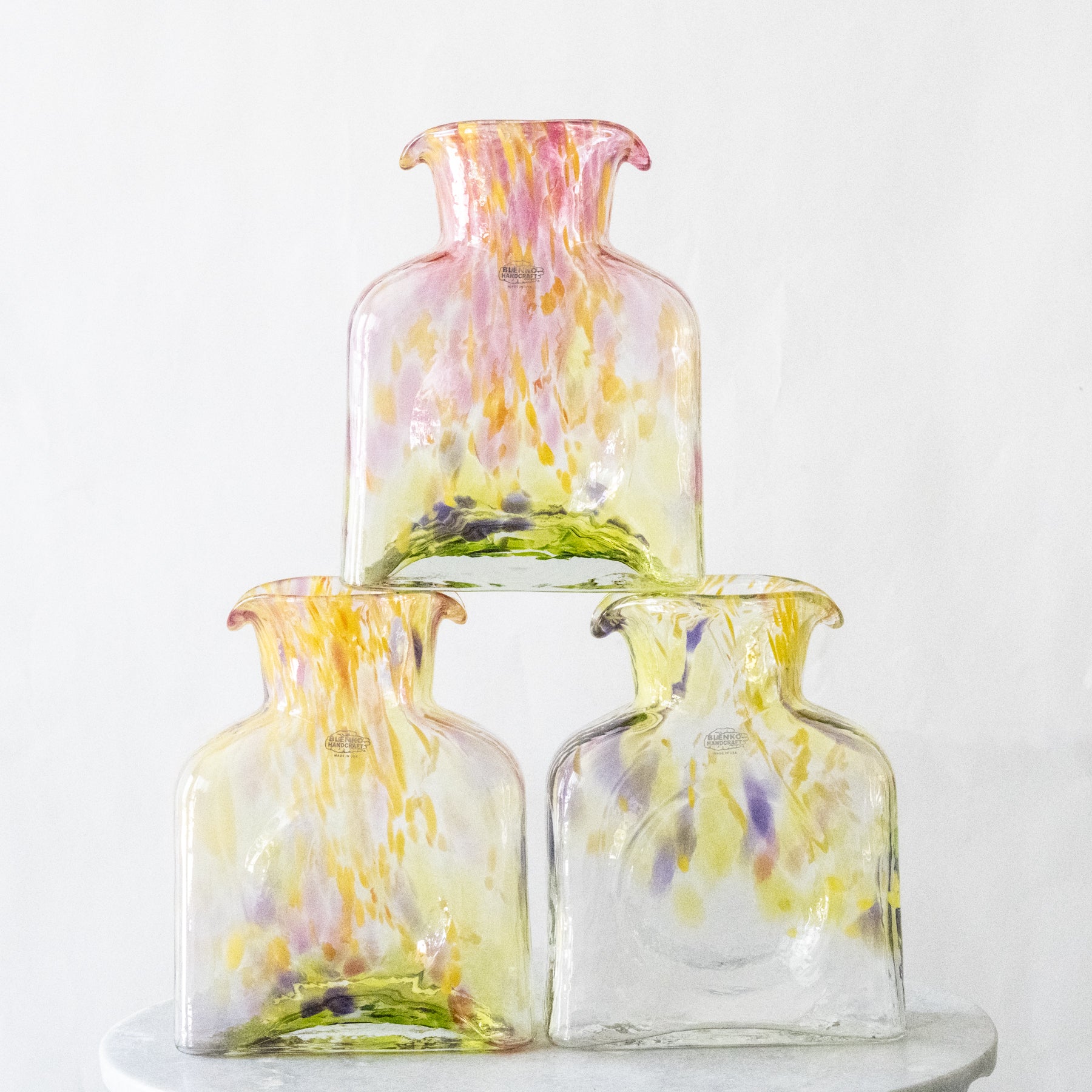 Set of three colorful glass vases on a white background