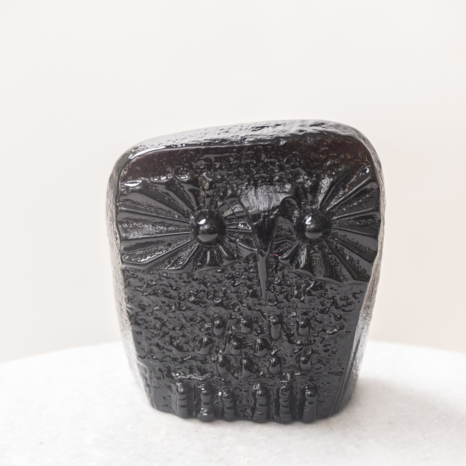 Black ceramic owl-shaped object on a white background