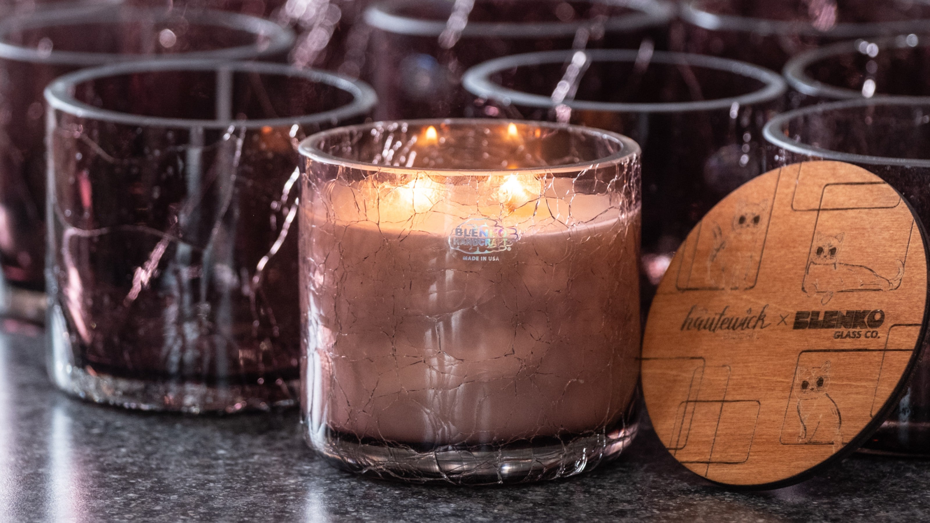 Row of glass candles with a wooden label on a dark surface