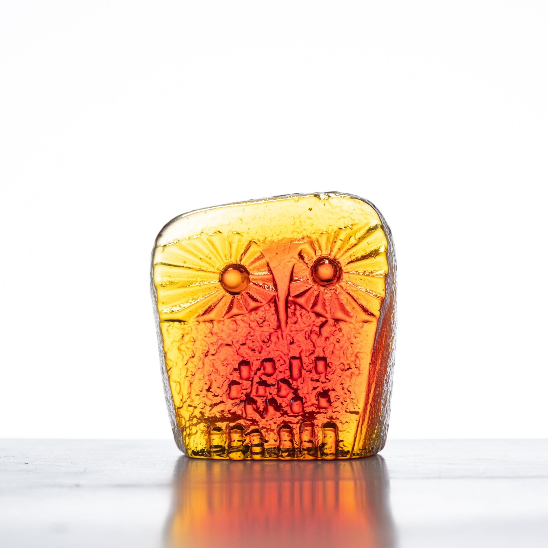 Handcrafted glass owl figurine with a tangerine orange color, featuring a flat back design.