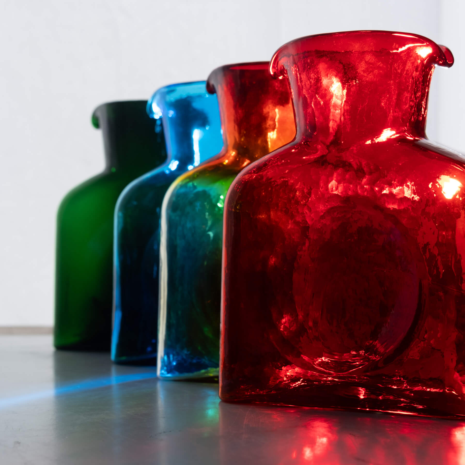 4 Blenko Water bottles with sunlight coming from behind