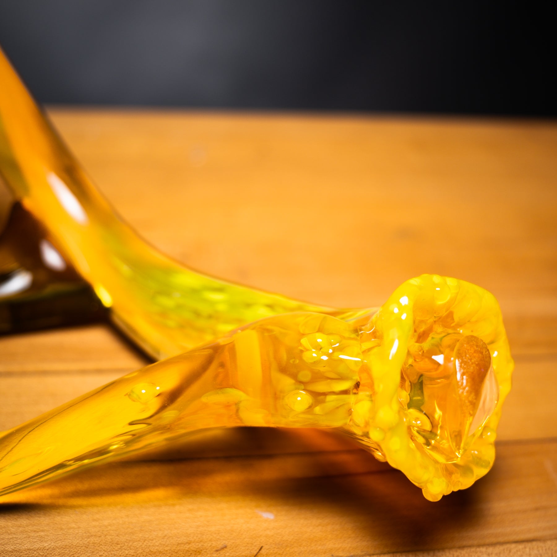 Yellow glass pipe on a wooden surface