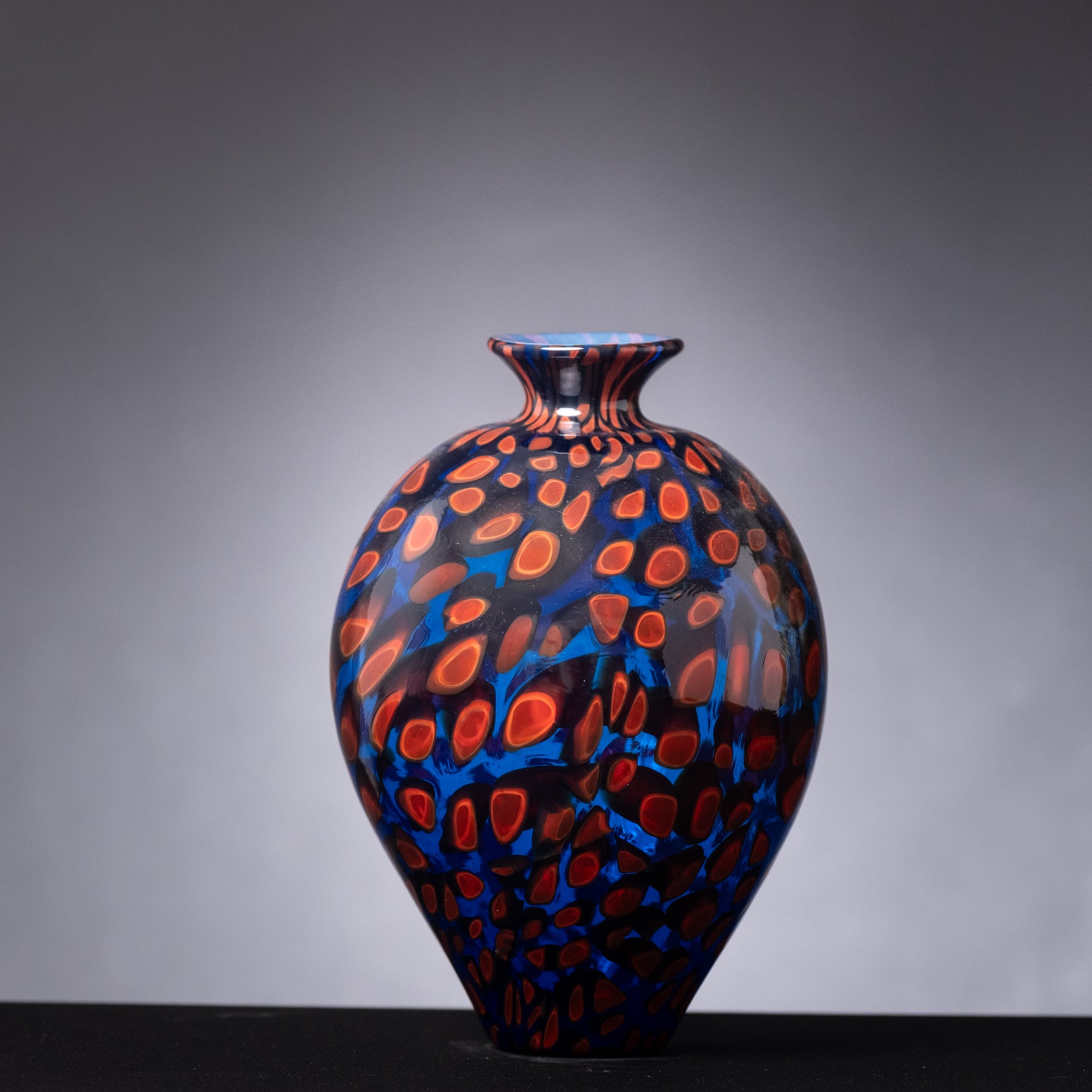Decorative vase with blue and orange pattern on a gray background