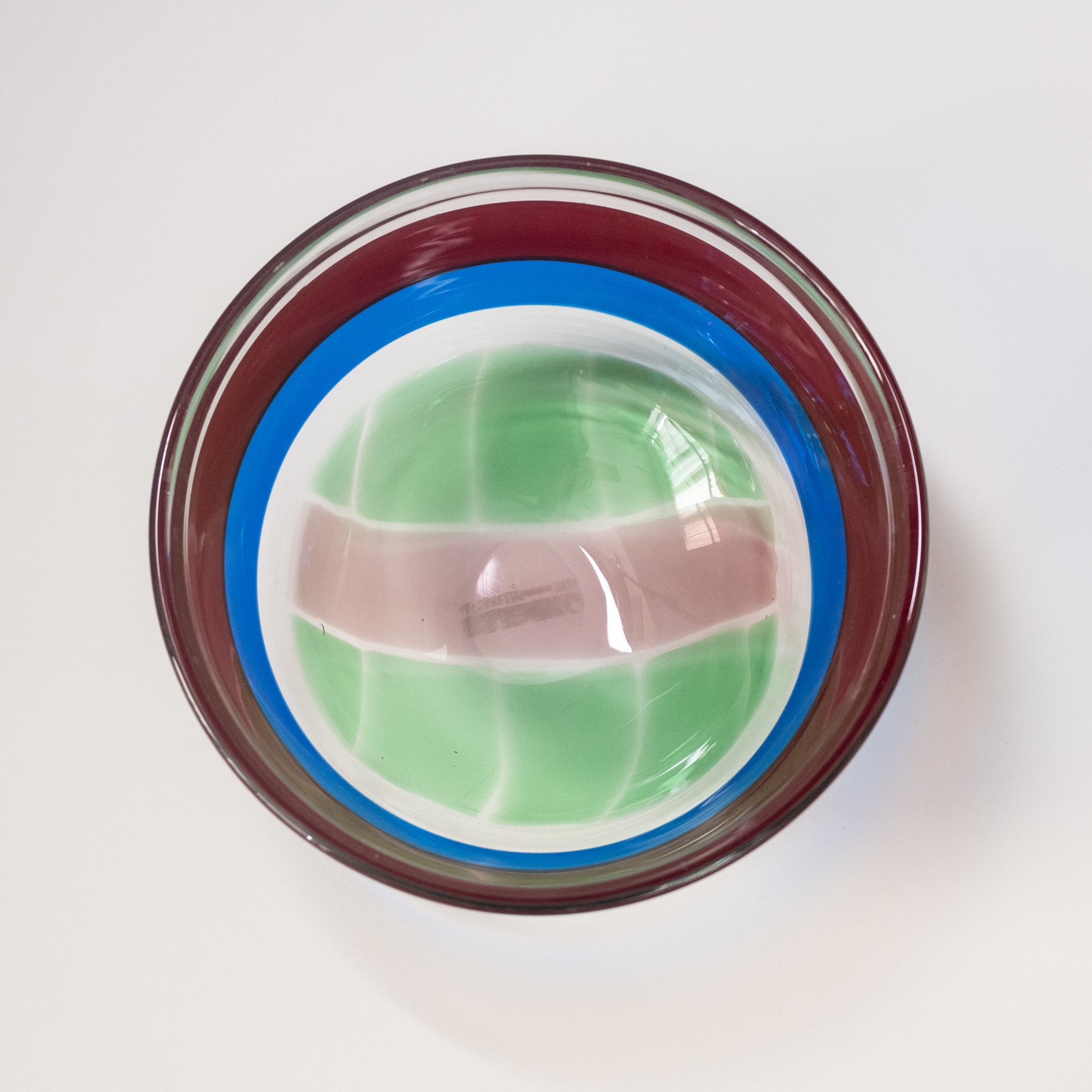 Glass container with a green and brown object inside on a white background