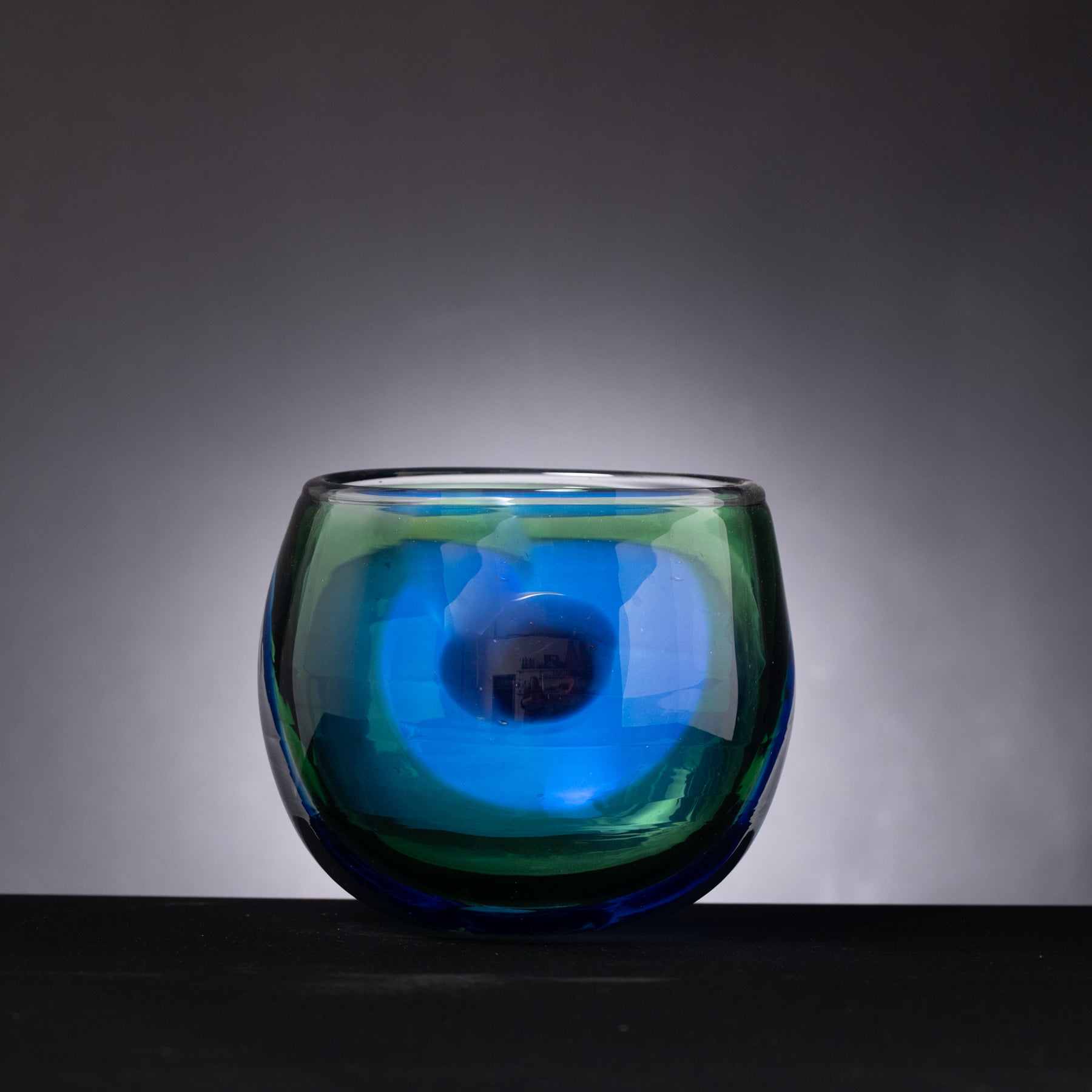 Blue glass candle holder on a dark background