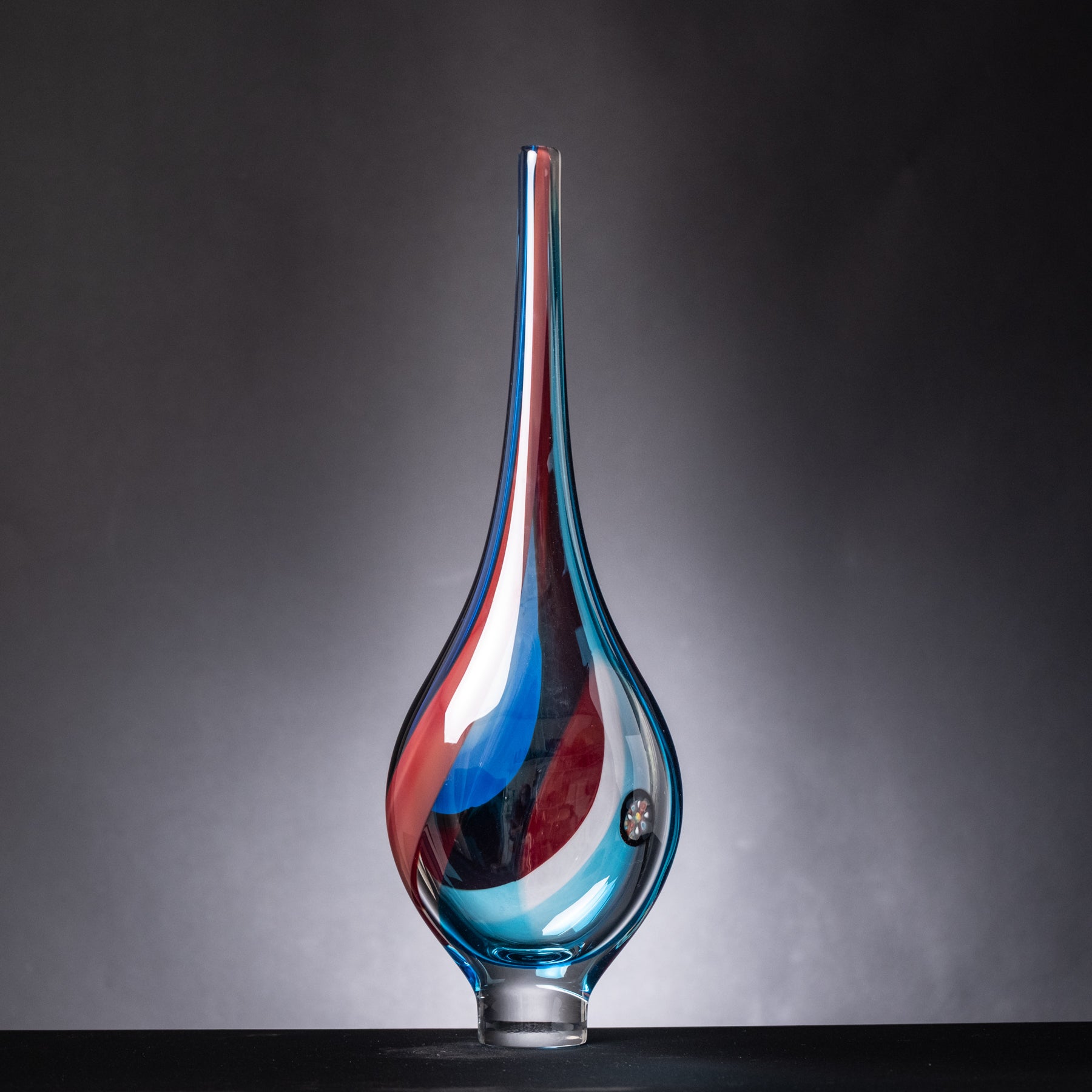 Glass vase with blue and red gradient on a dark background