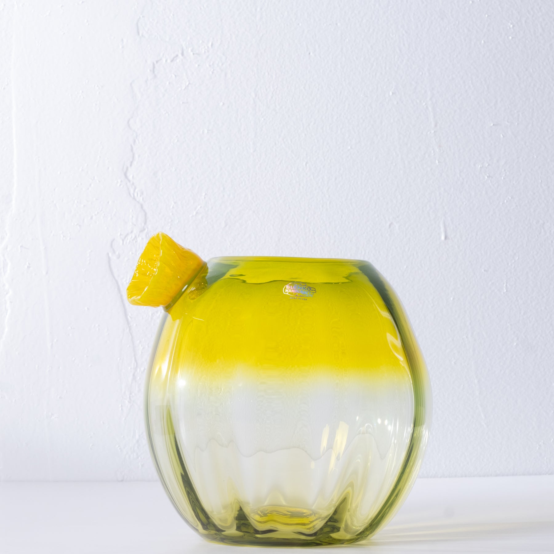 Yellow glass cactus with yellow flower on white background.