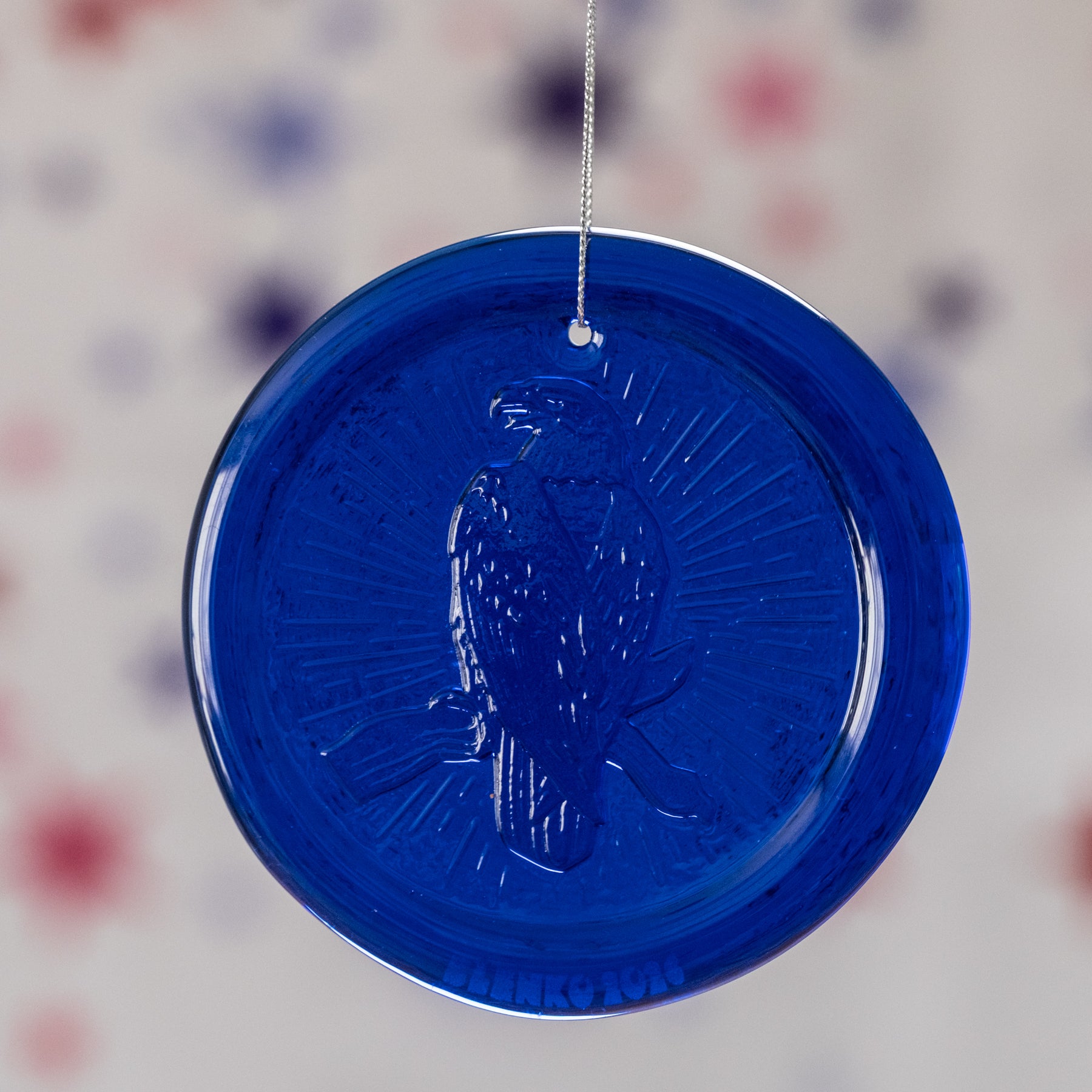 blue circular ornament with textured surface on a blurred background