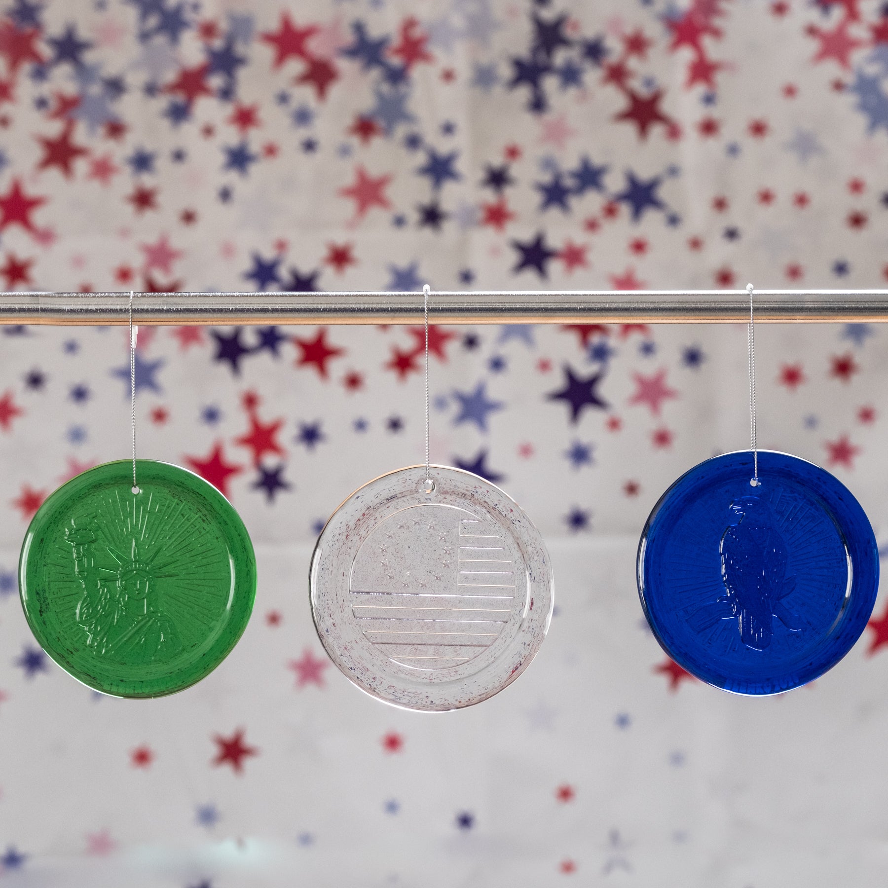 Three colorful coins hanging on a string against a star-patterned background