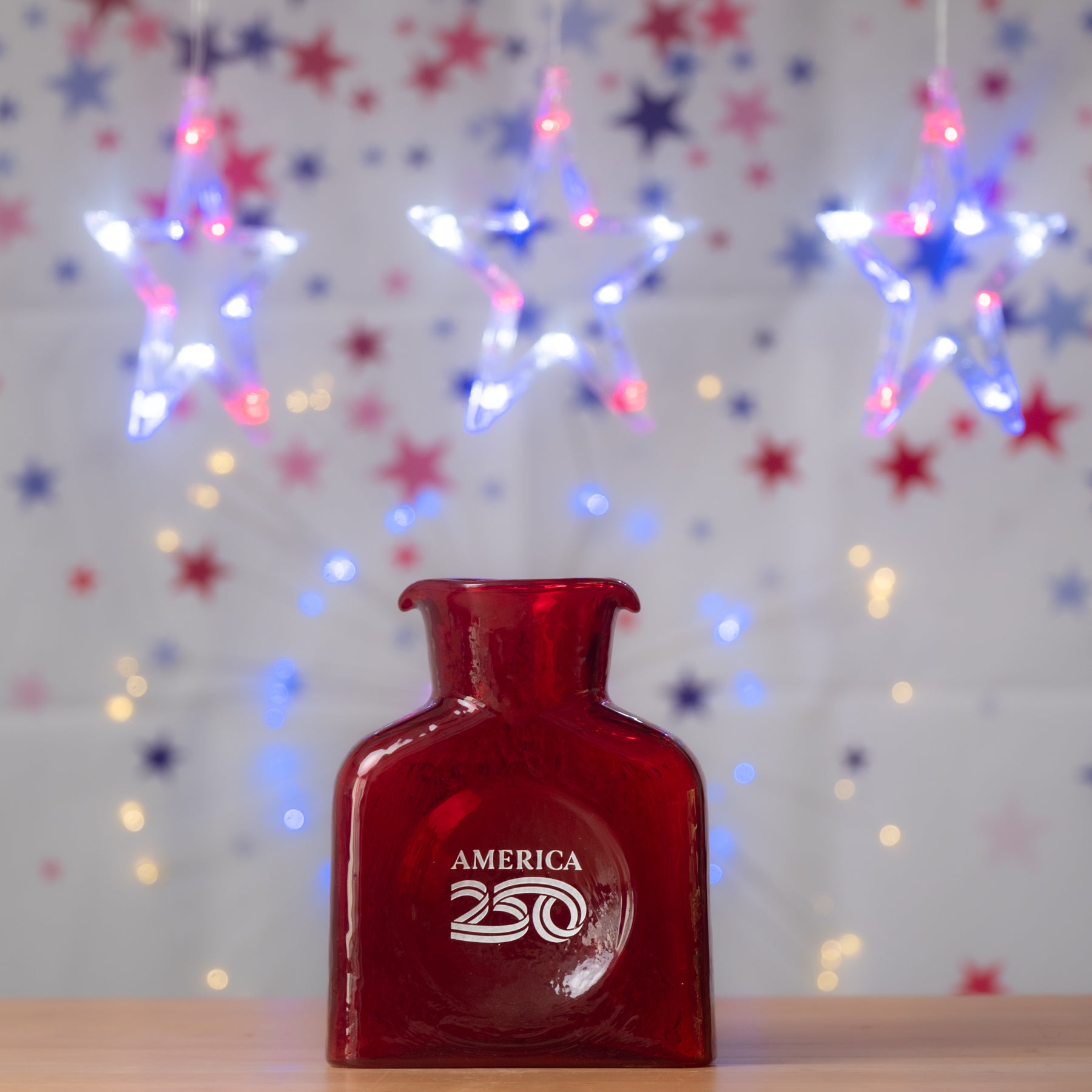 Red bottle labeled 'America 250' with festive lights and stars in the background