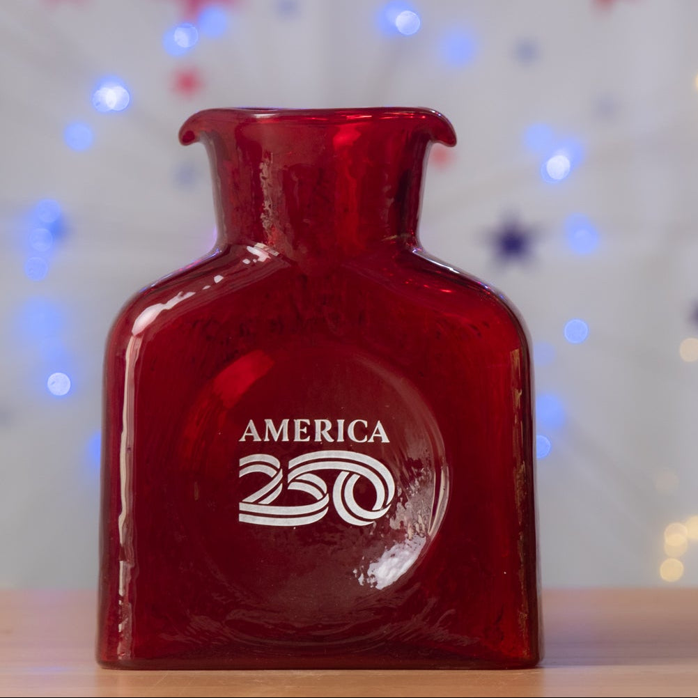 Red bottle labeled 'America 250' with festive lights and stars in the background