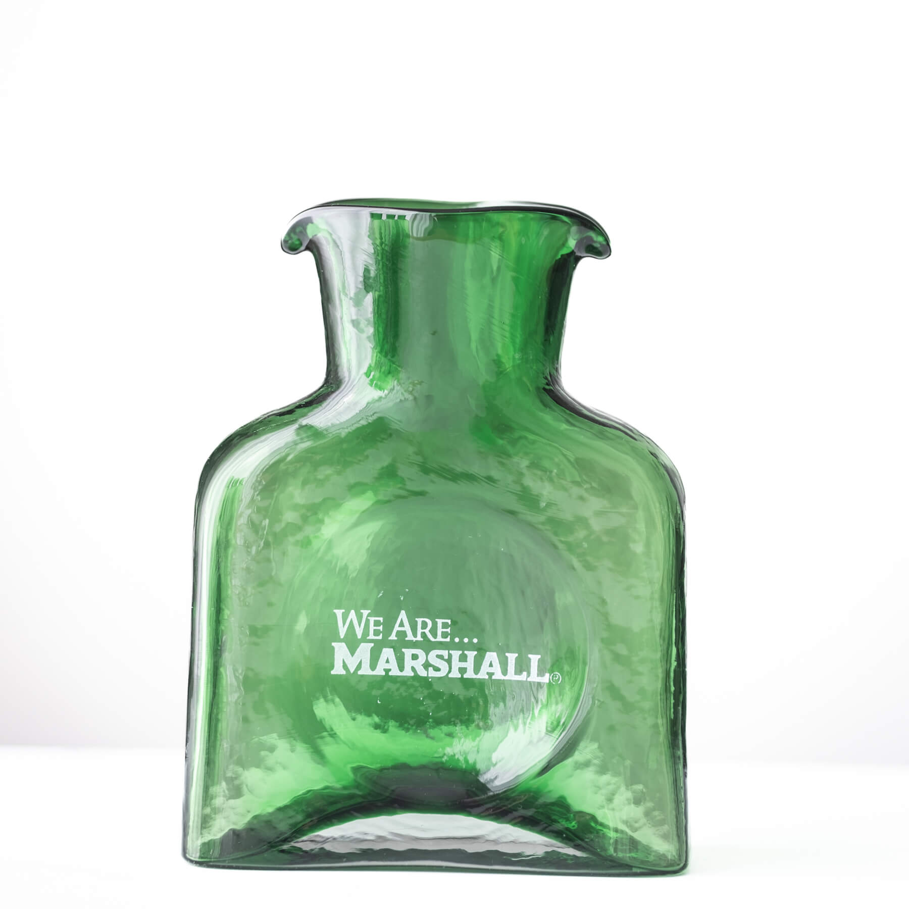 A green glass bottle vase with a flared neck and the text 'We Are.