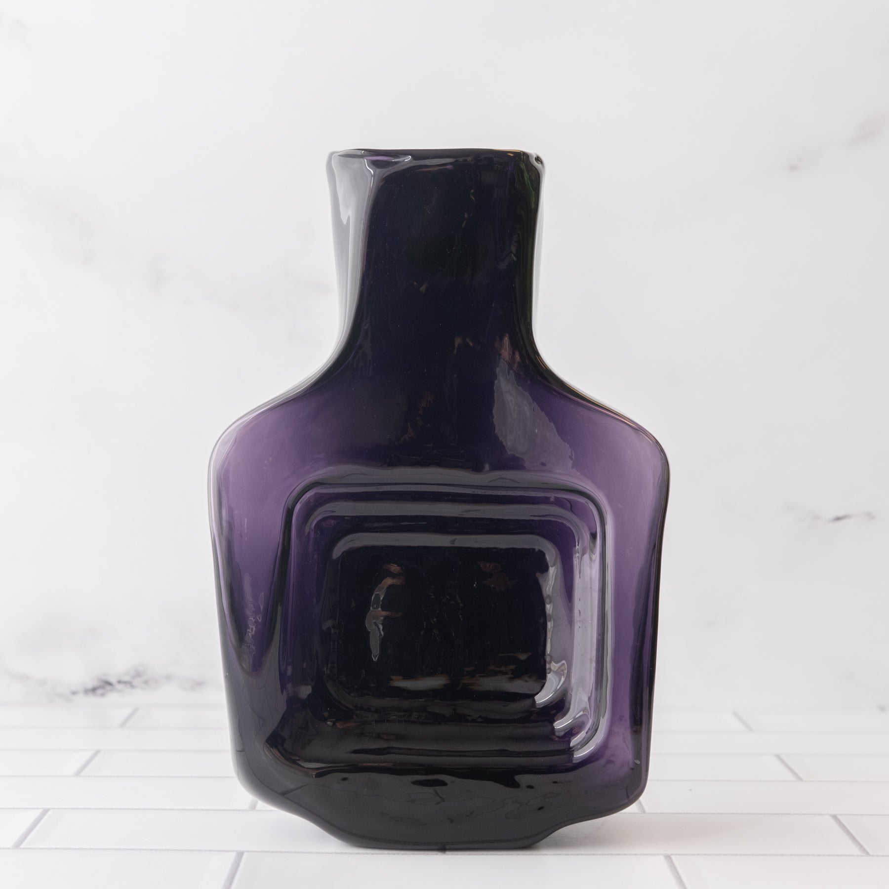 Dark purple bottle with square design in it's center