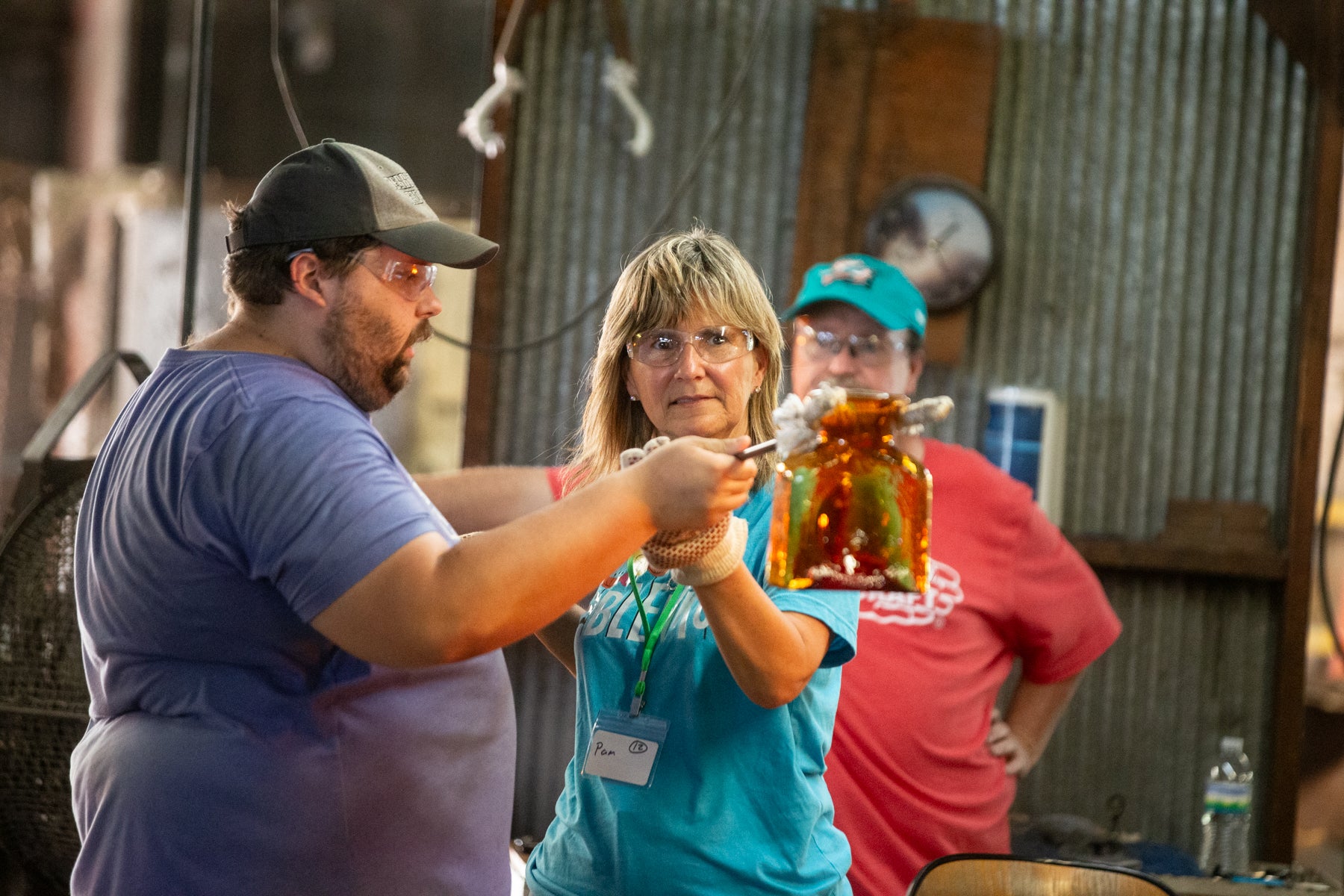 Two people holding a glass jar with a candle inside, surrounded by rustic decor.