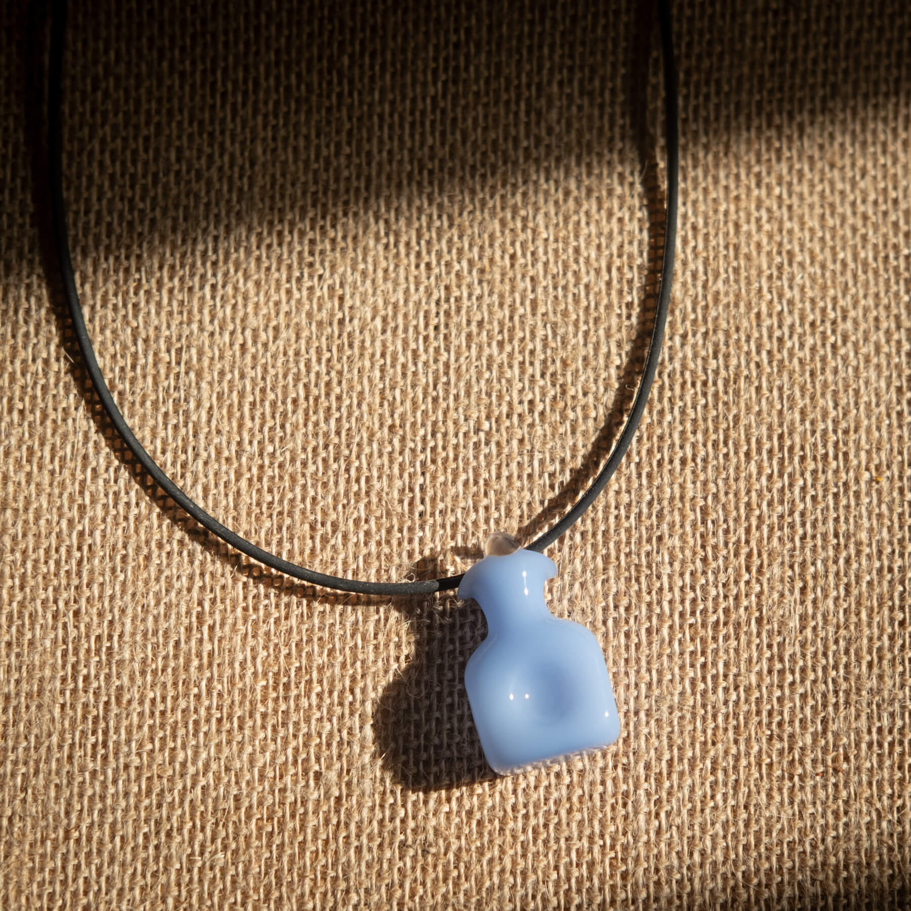 Necklace with a blue pendant on a textured brown background
