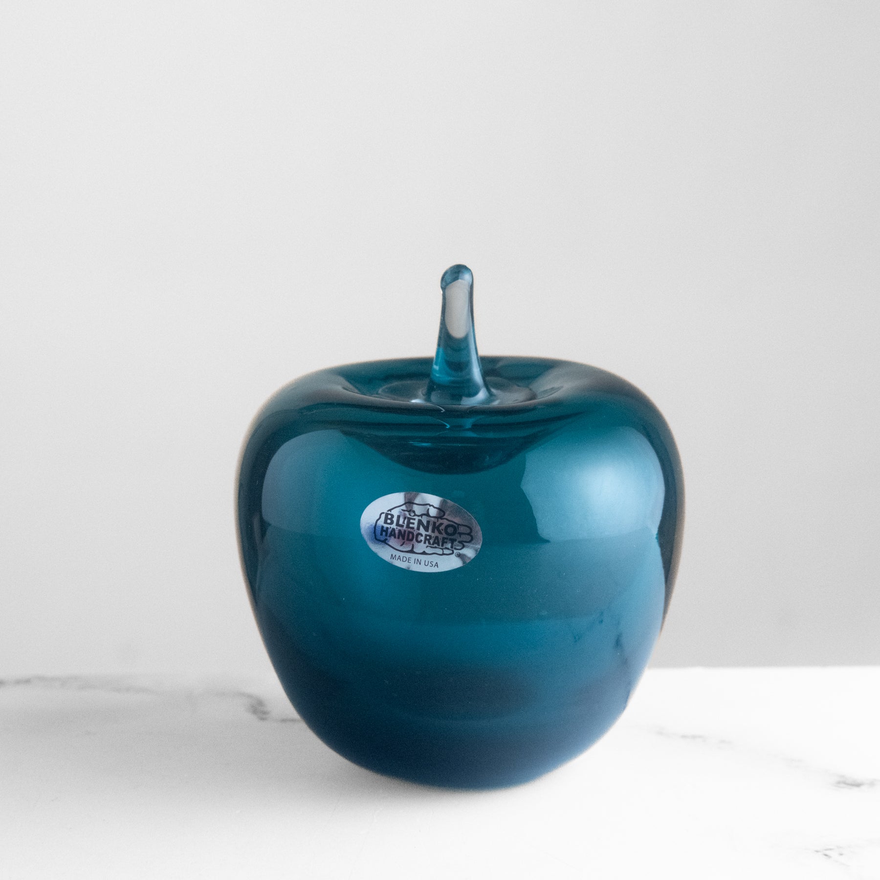 Cerulean glass apple with 'Blenko' label on a white background