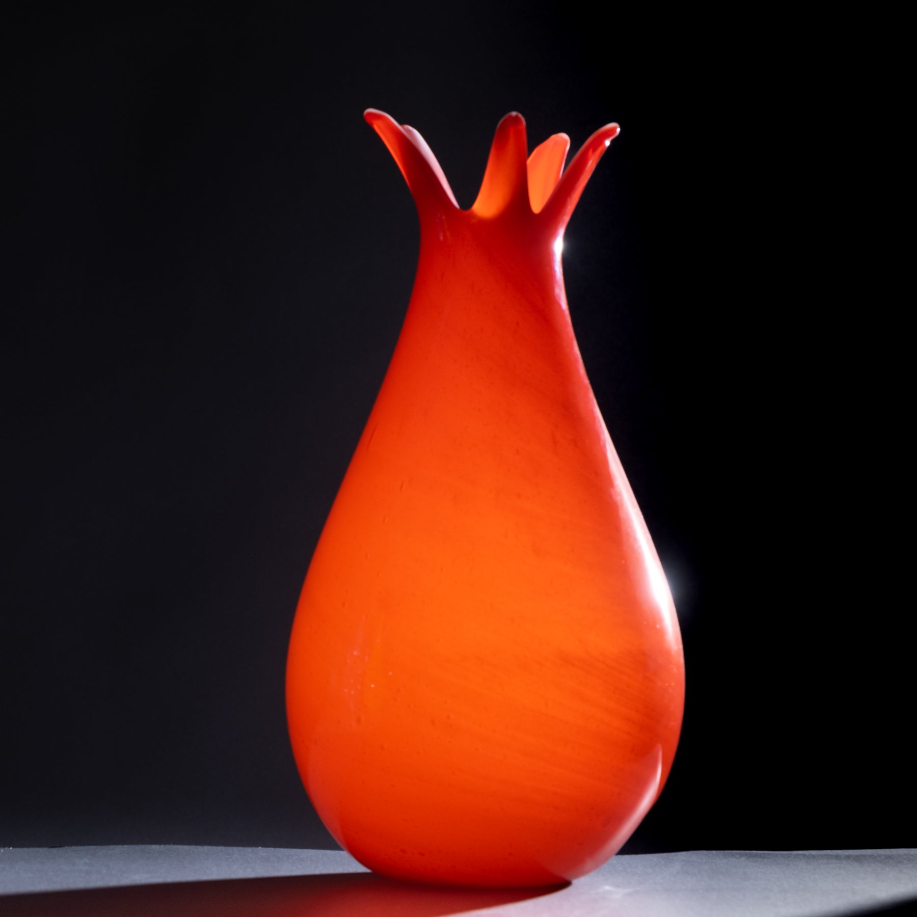 Orange vase with a unique design on a black background