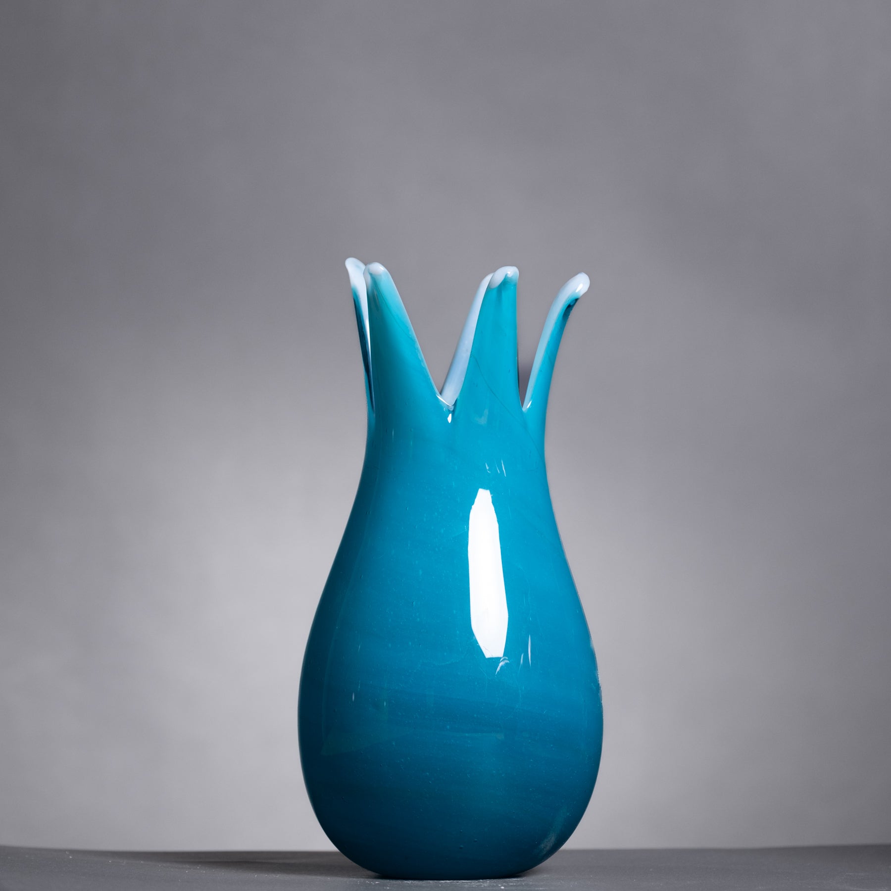 Blue vase with a unique design on a gray background