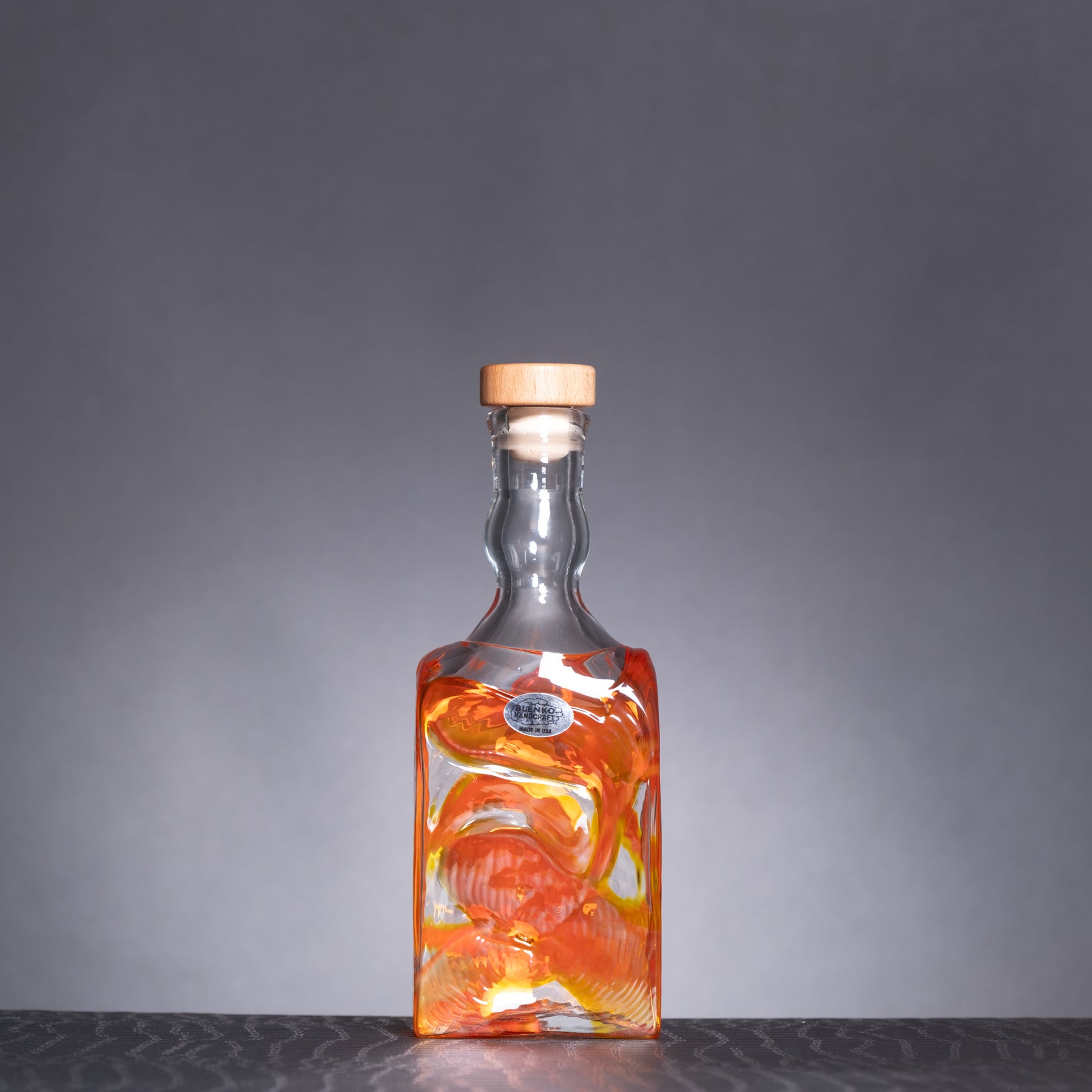 Glass bottle with a cork stopper on a gray background