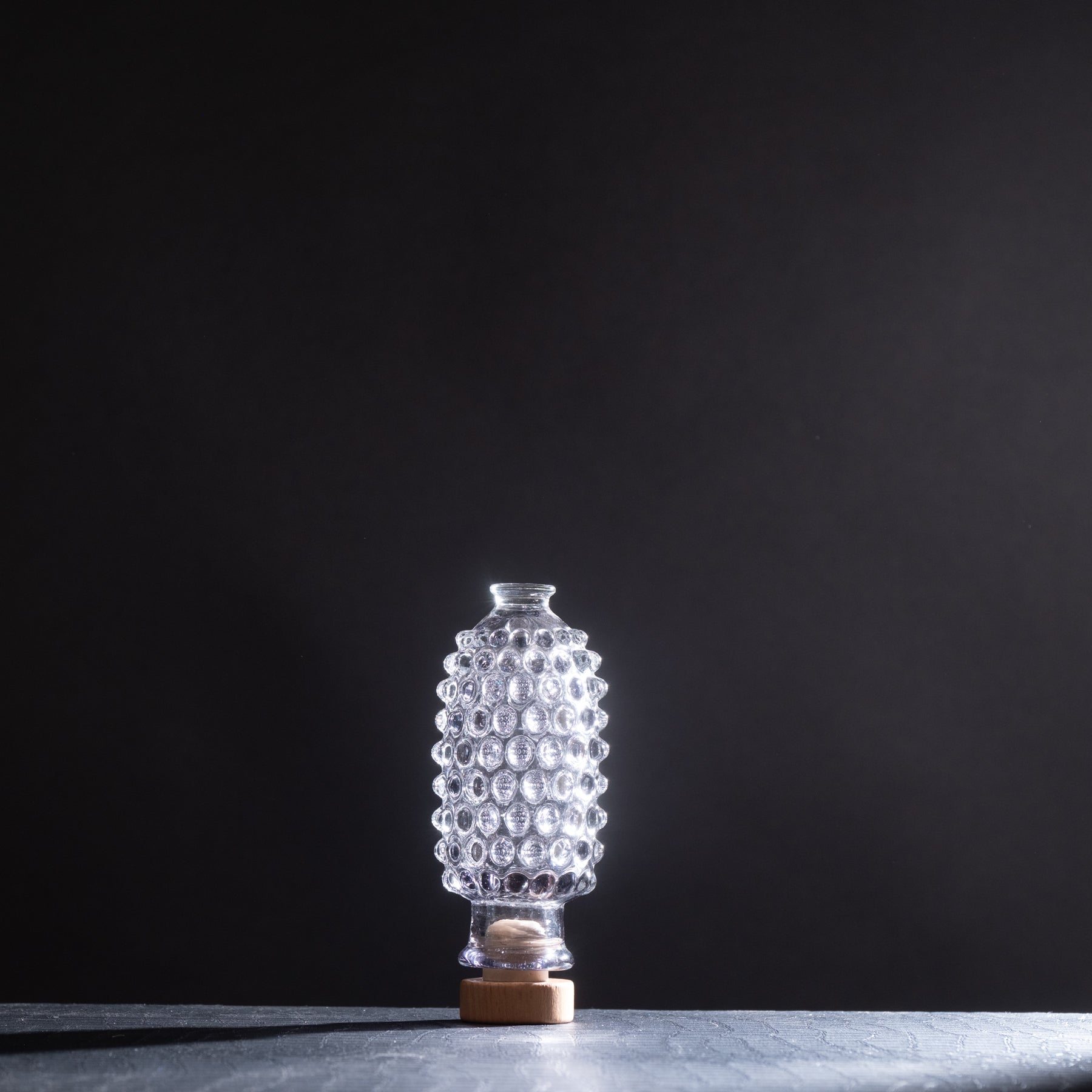 Clear glass textured lamp on a dark background