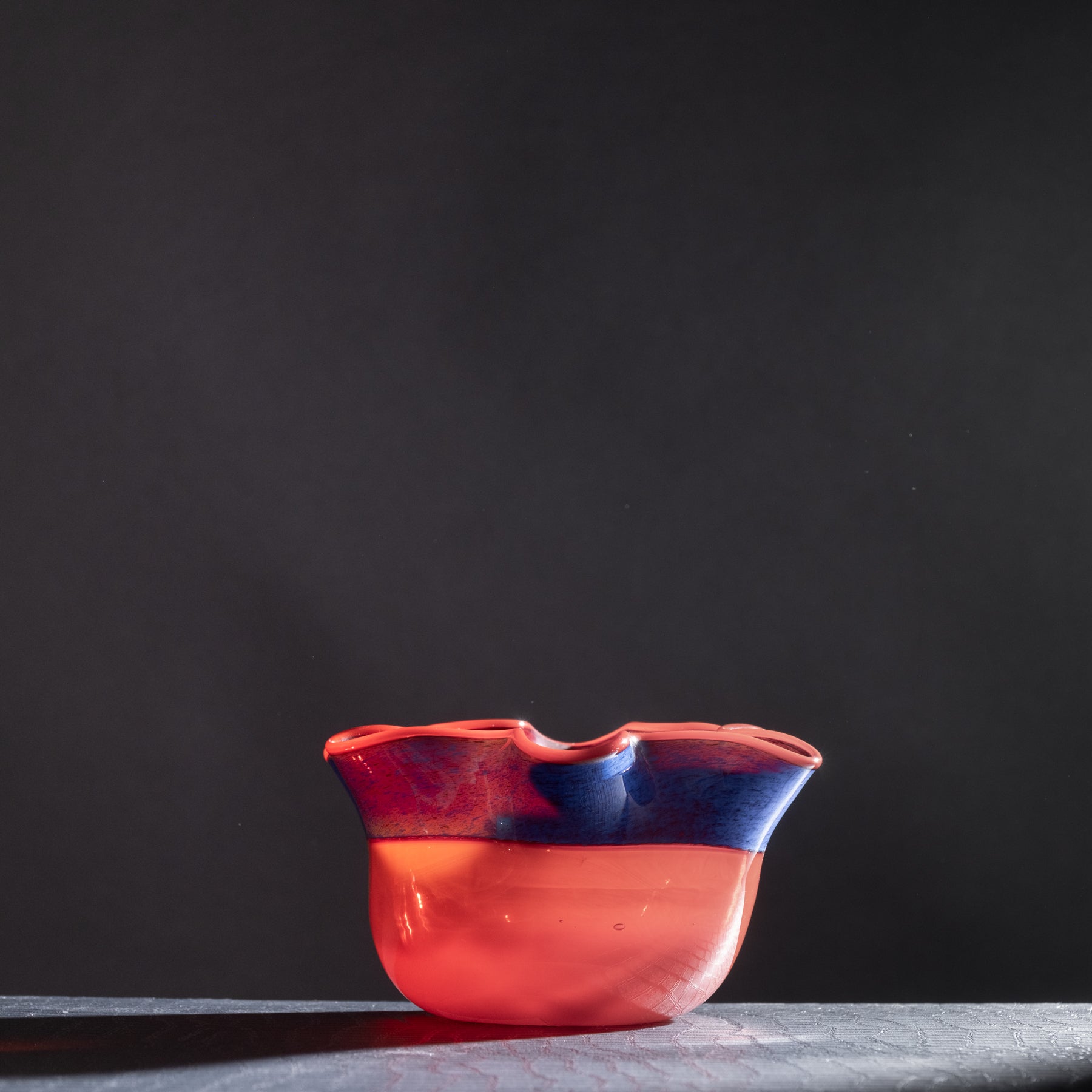 Red and blue ceramic bowl on a dark background