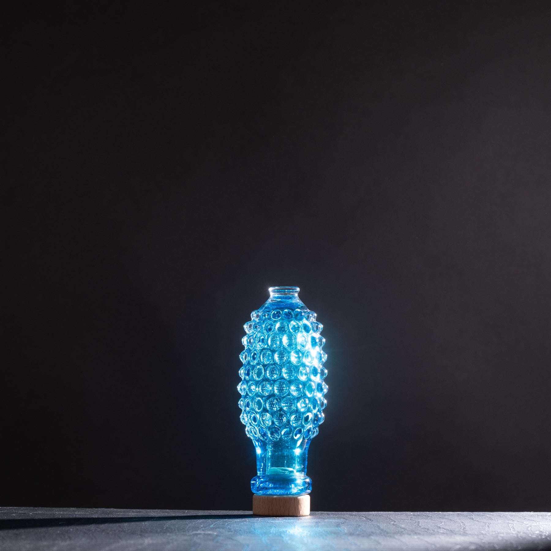 Blue textured vase on a dark background