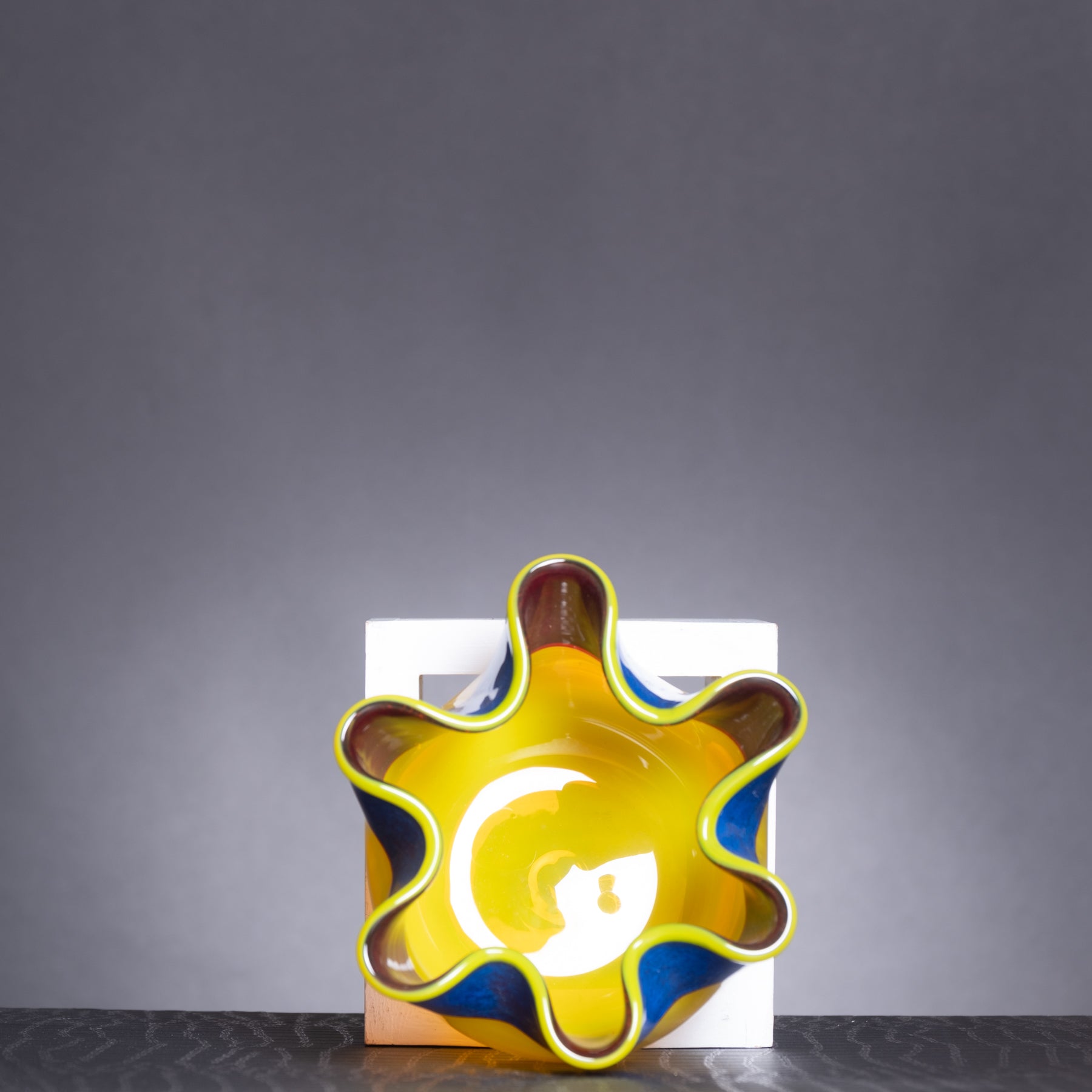 Decorative vase with a sun design on a gray background