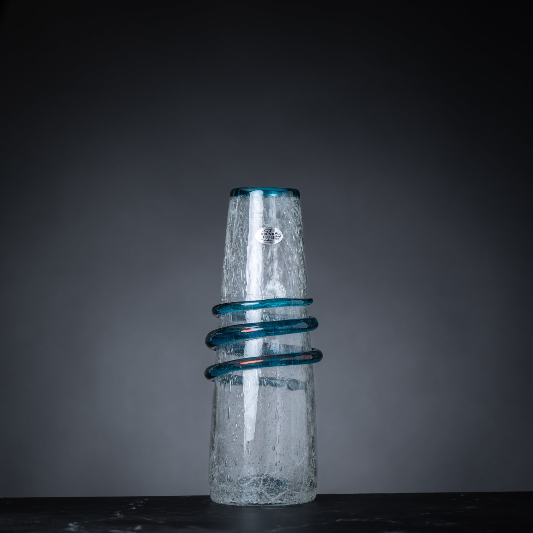 Glass vase with blue accents on a dark background