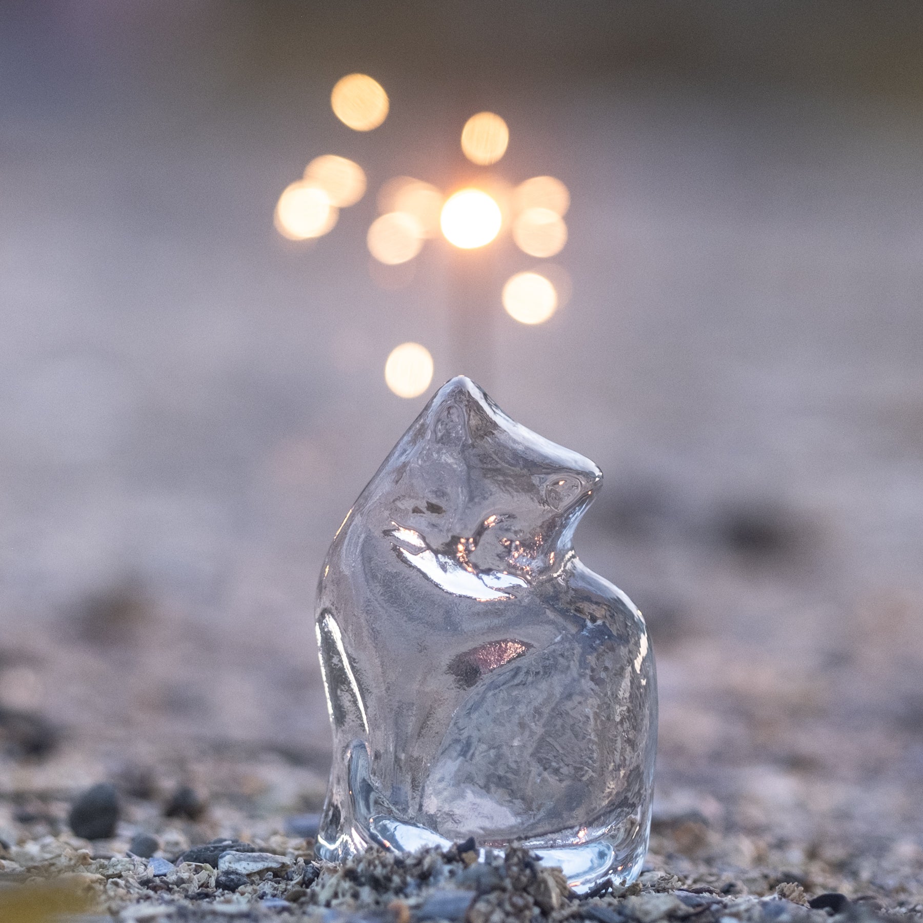 Crystal cat figural with beach scene in background