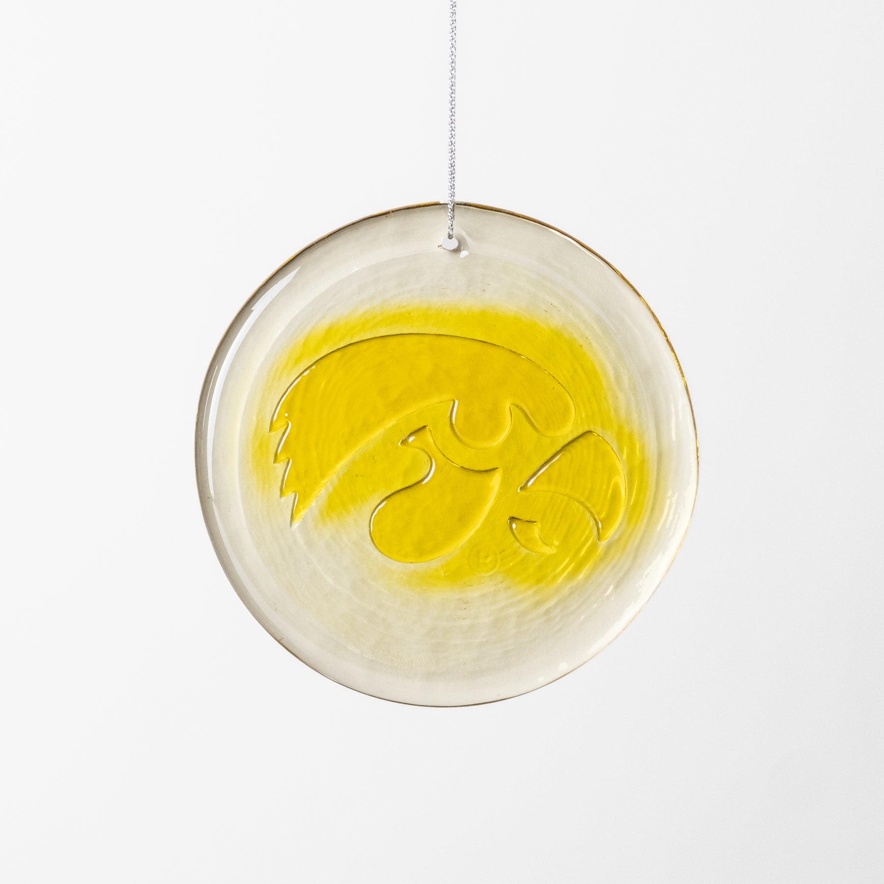 Decorative glass ornament with yellow design on a white background