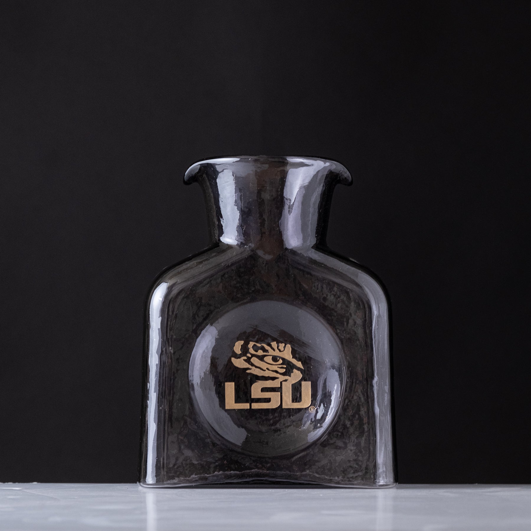 Purple vase with LSU logo on a dark background